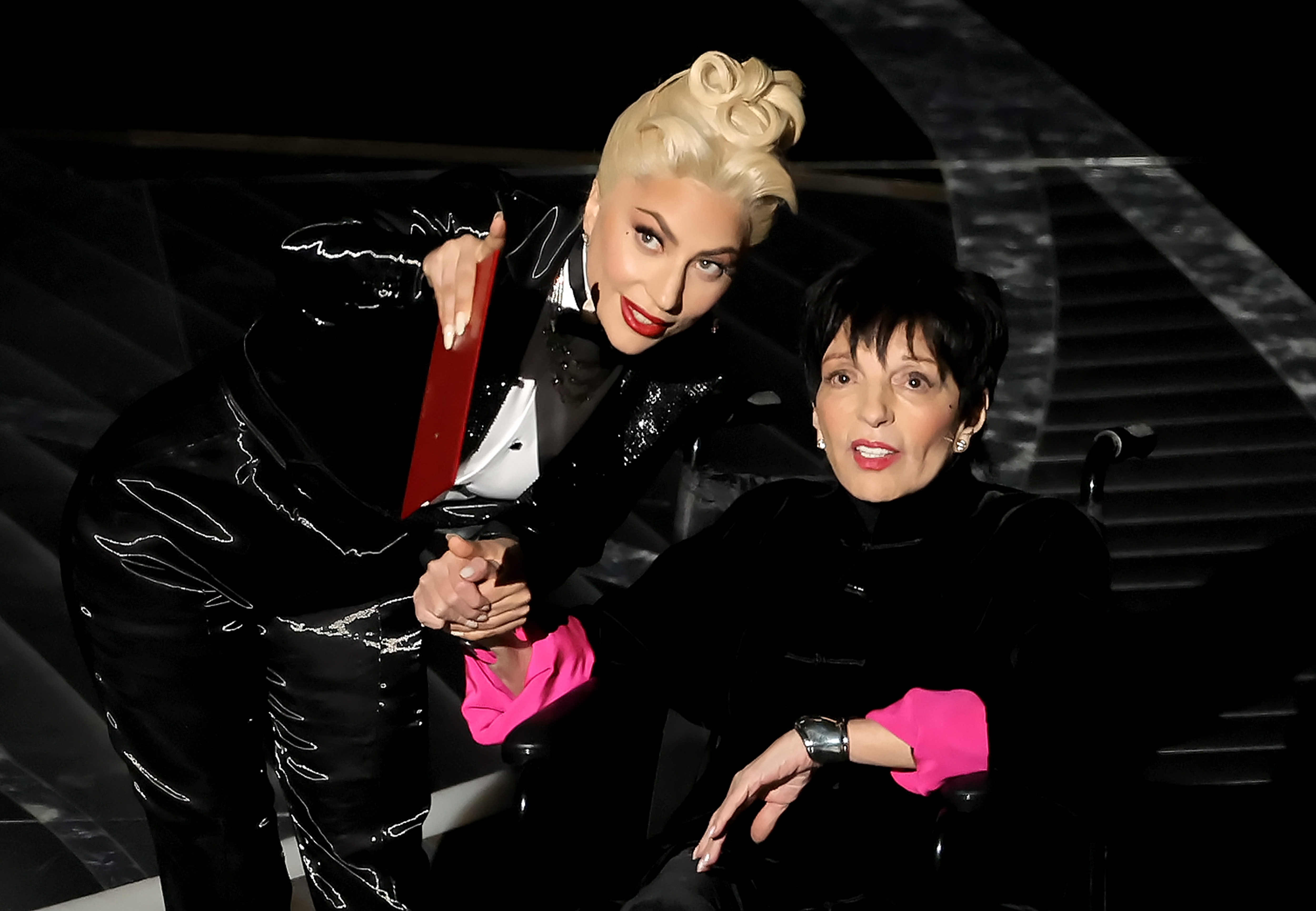 Lady Gaga holds hands with Liza Minnelli connected  the 2022 Oscars signifier    and points astatine  thing  with the different   hand