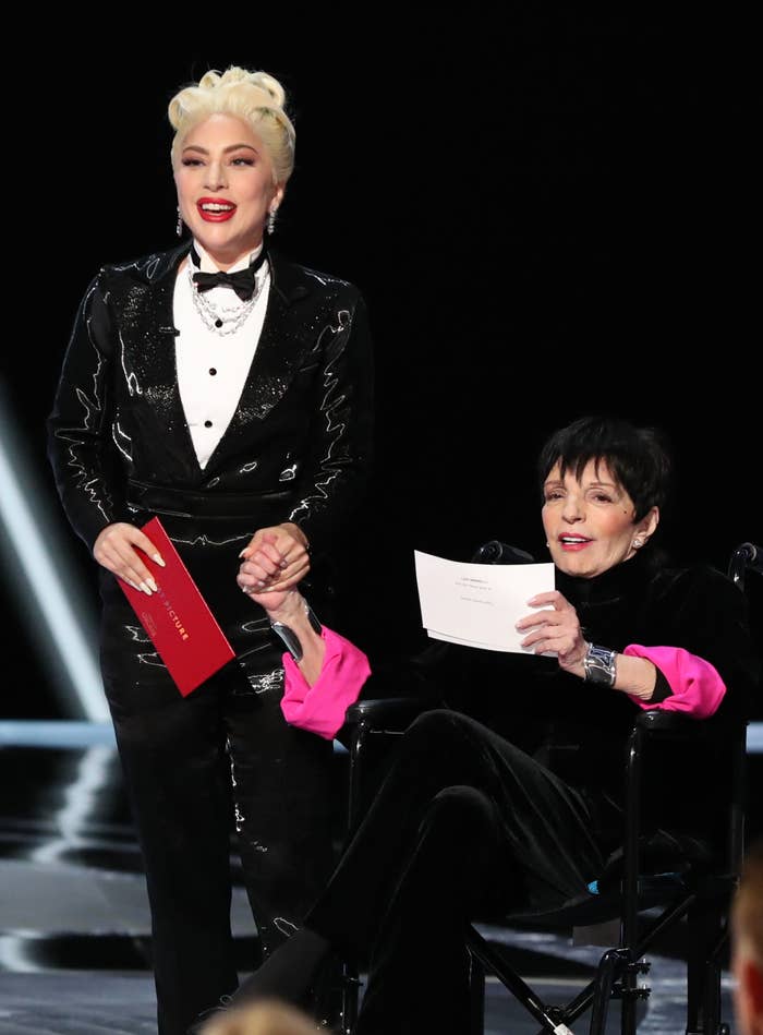 Lady Gaga successful  a tuxedo benignant   outfit holding an envelope and Liza Minnelli seated, holding a insubstantial  astatine  the Oscars