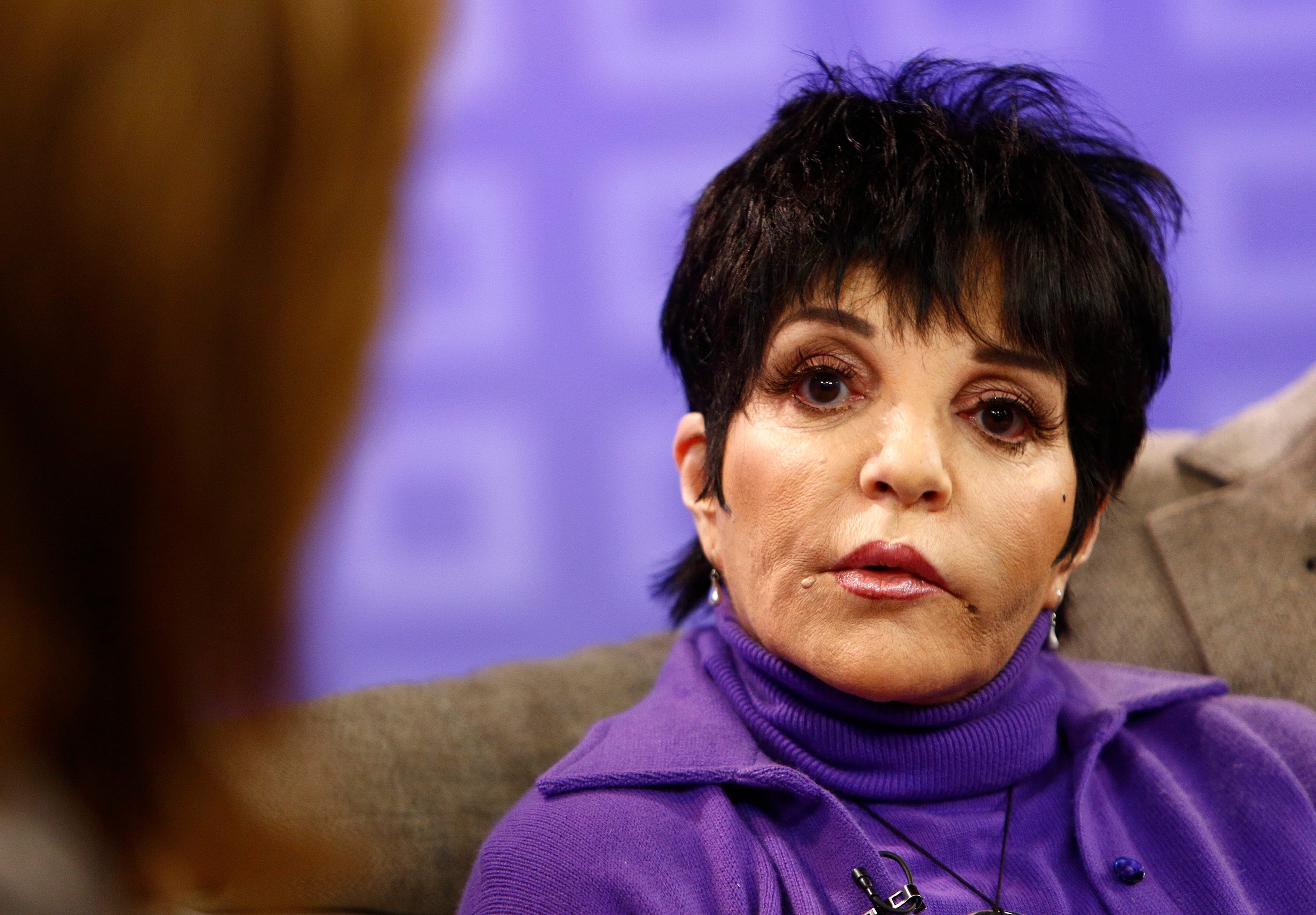 Liza Minnelli with abbreviated  hair, wearing a stylish outfit, listens intently successful  an interrogation  setting