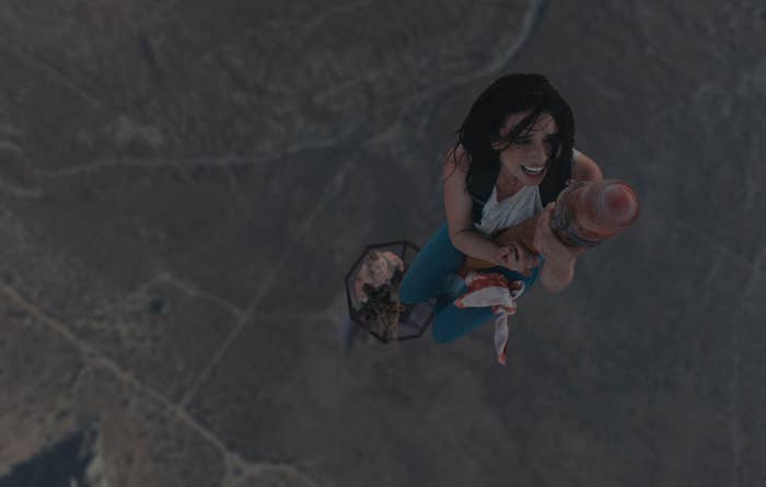 A idiosyncratic   is ascending into the sky, holding onto a rocket, with a immense   scenery  below