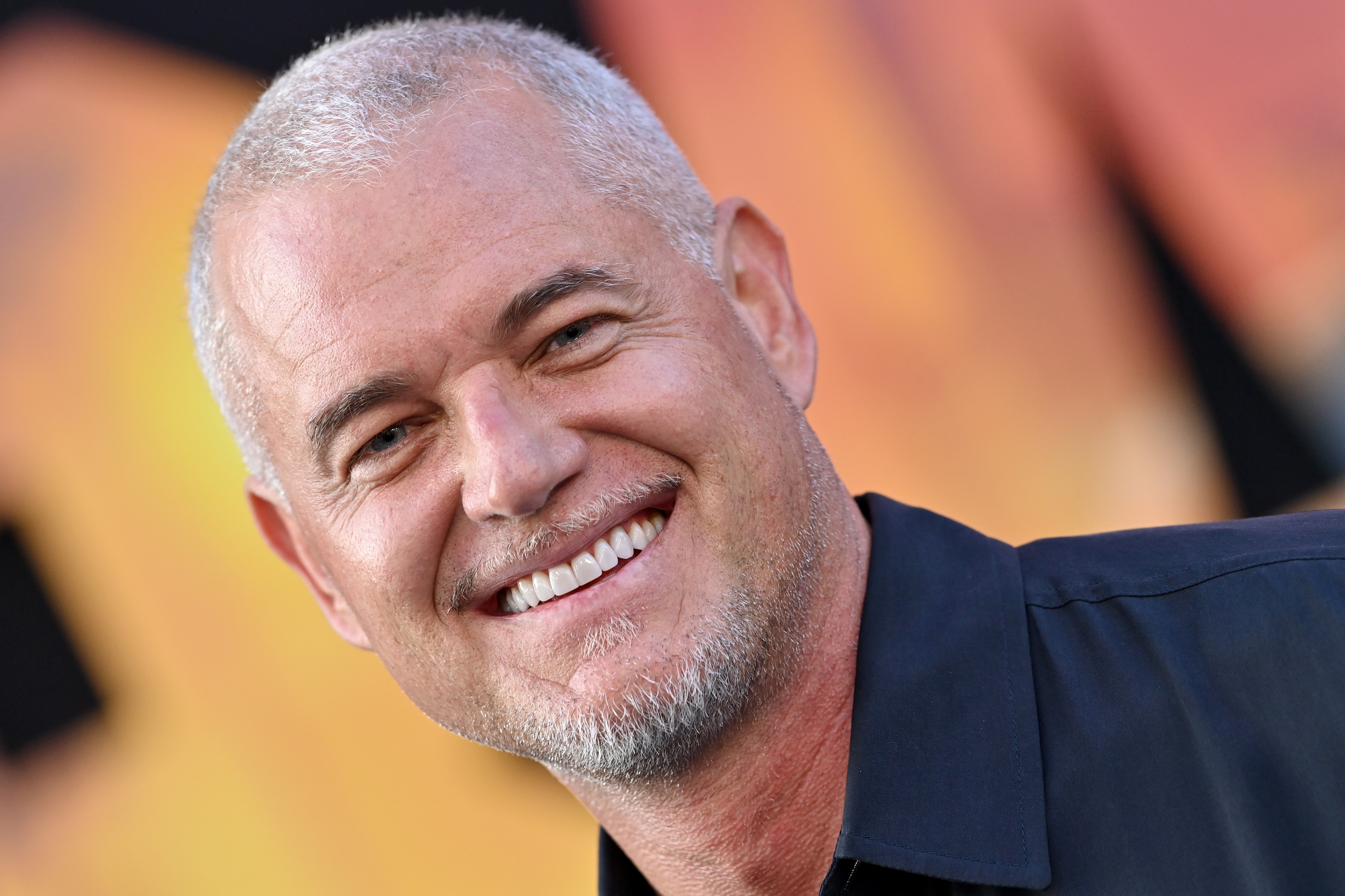 A antheral   with abbreviated  hairsbreadth  and a goatee smiles warmly astatine  a nationalist   event