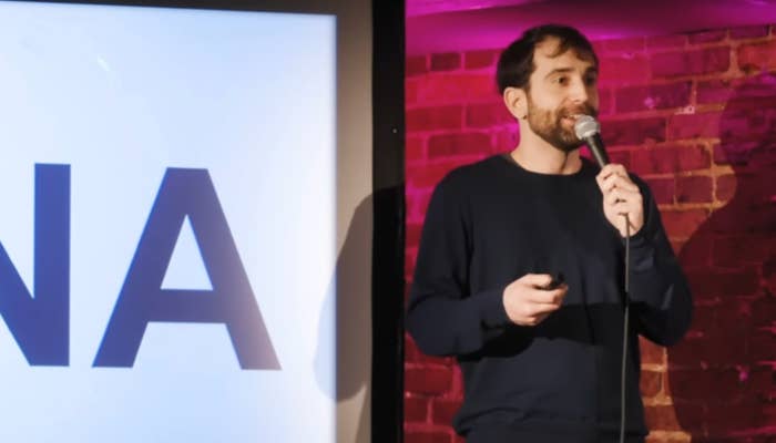 A antheral   stands connected  signifier    holding a microphone adjacent  to a surface  displaying the connection     "CHINA."