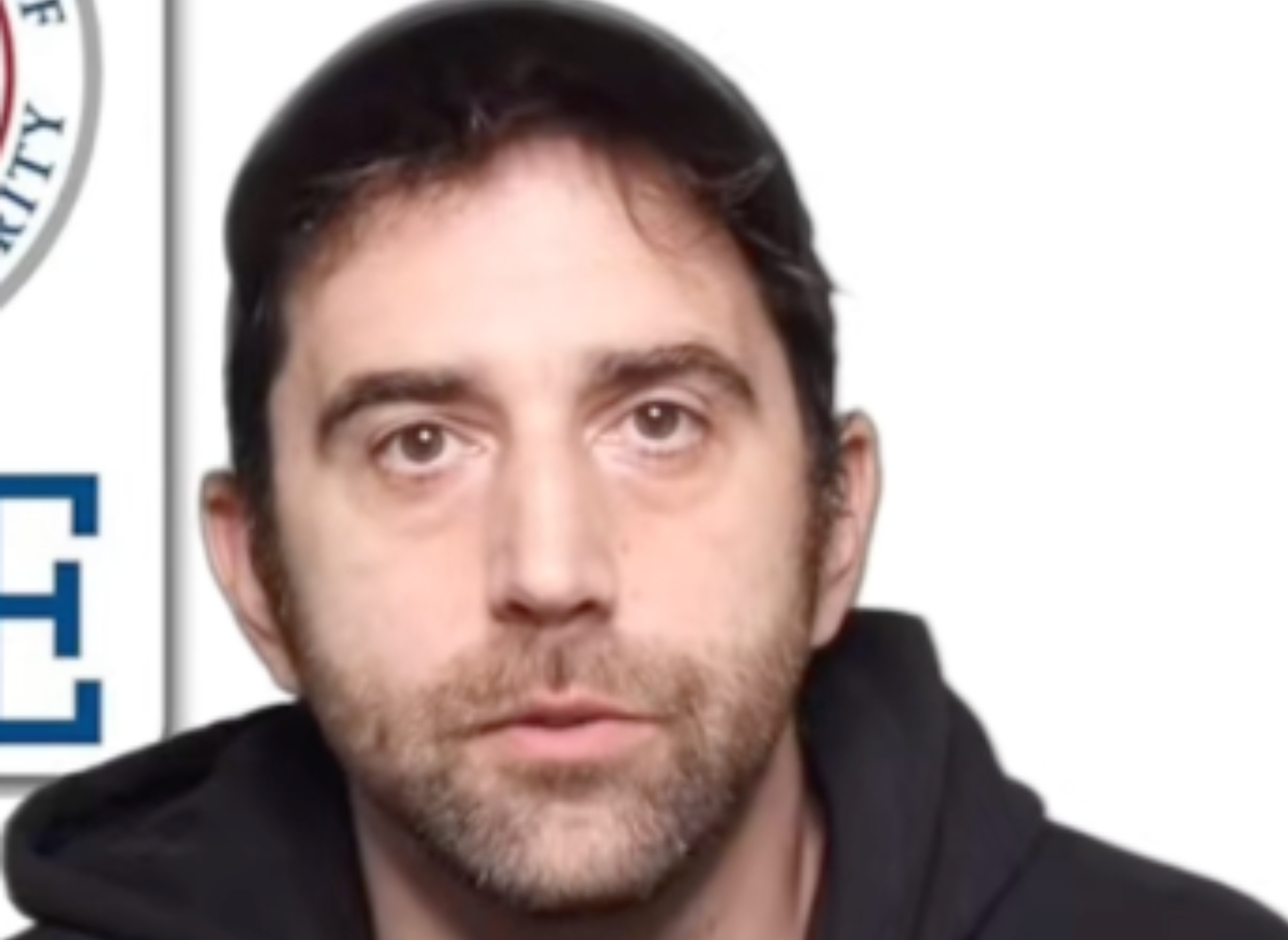 Man wearing a casual hoodie and cap, posing against a plain background, with portion  of a seal disposable   successful  the corner