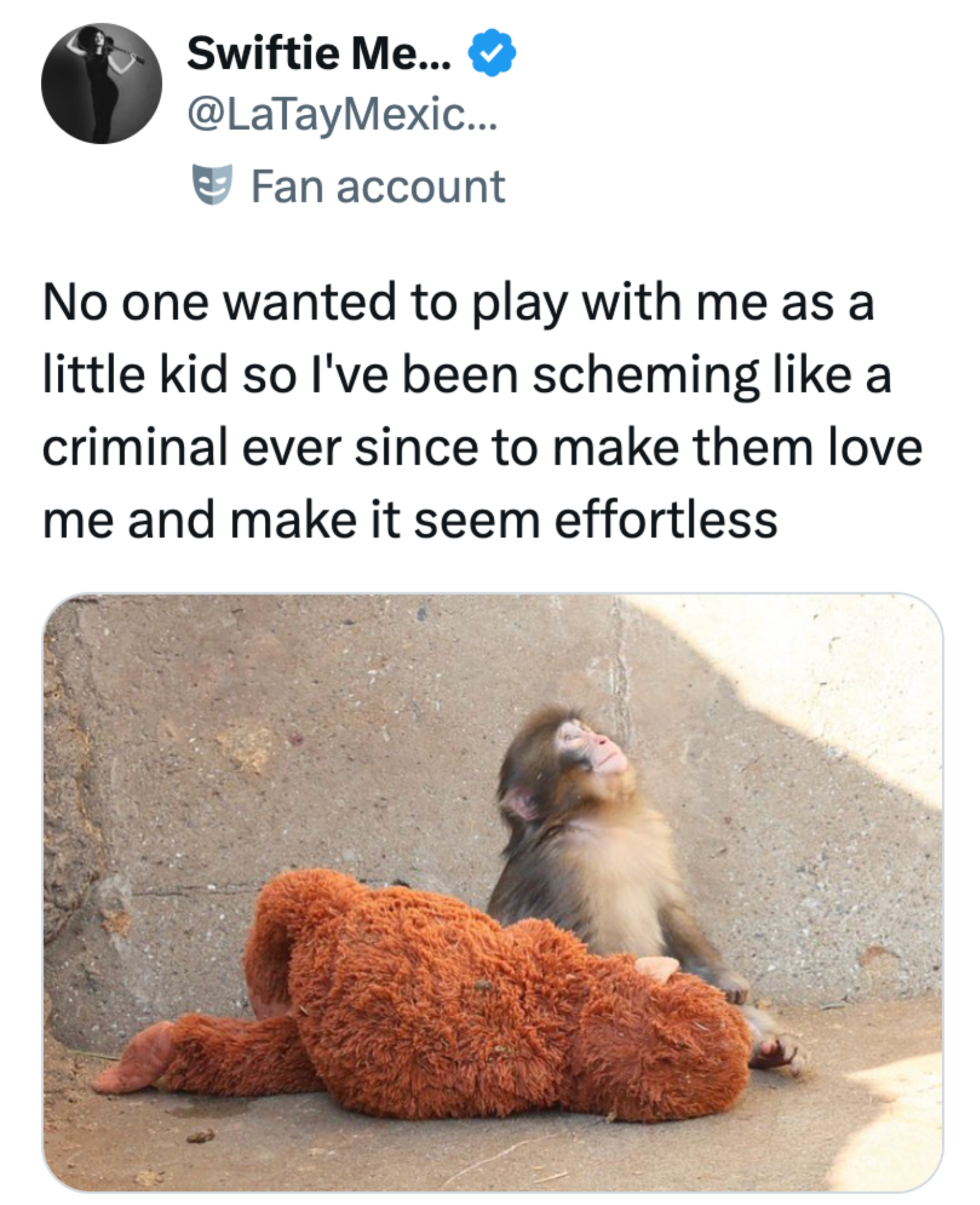 Babybavian lener seg mot en stein, ved siden av et stort plysjleketøy, med en humoristisk tweet om å søke hengivenhet og aksept