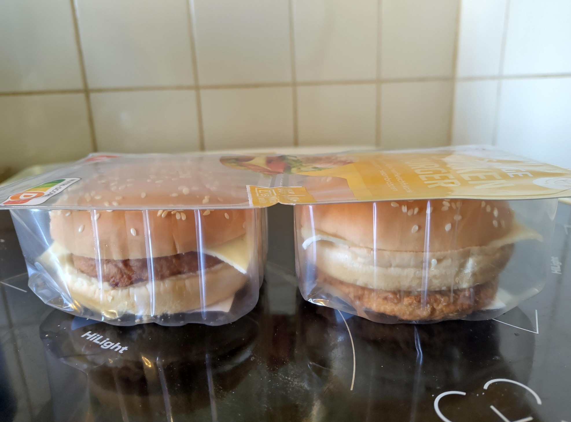 Two packaged chicken sandwiches; one with the chicken on the outside of the bun