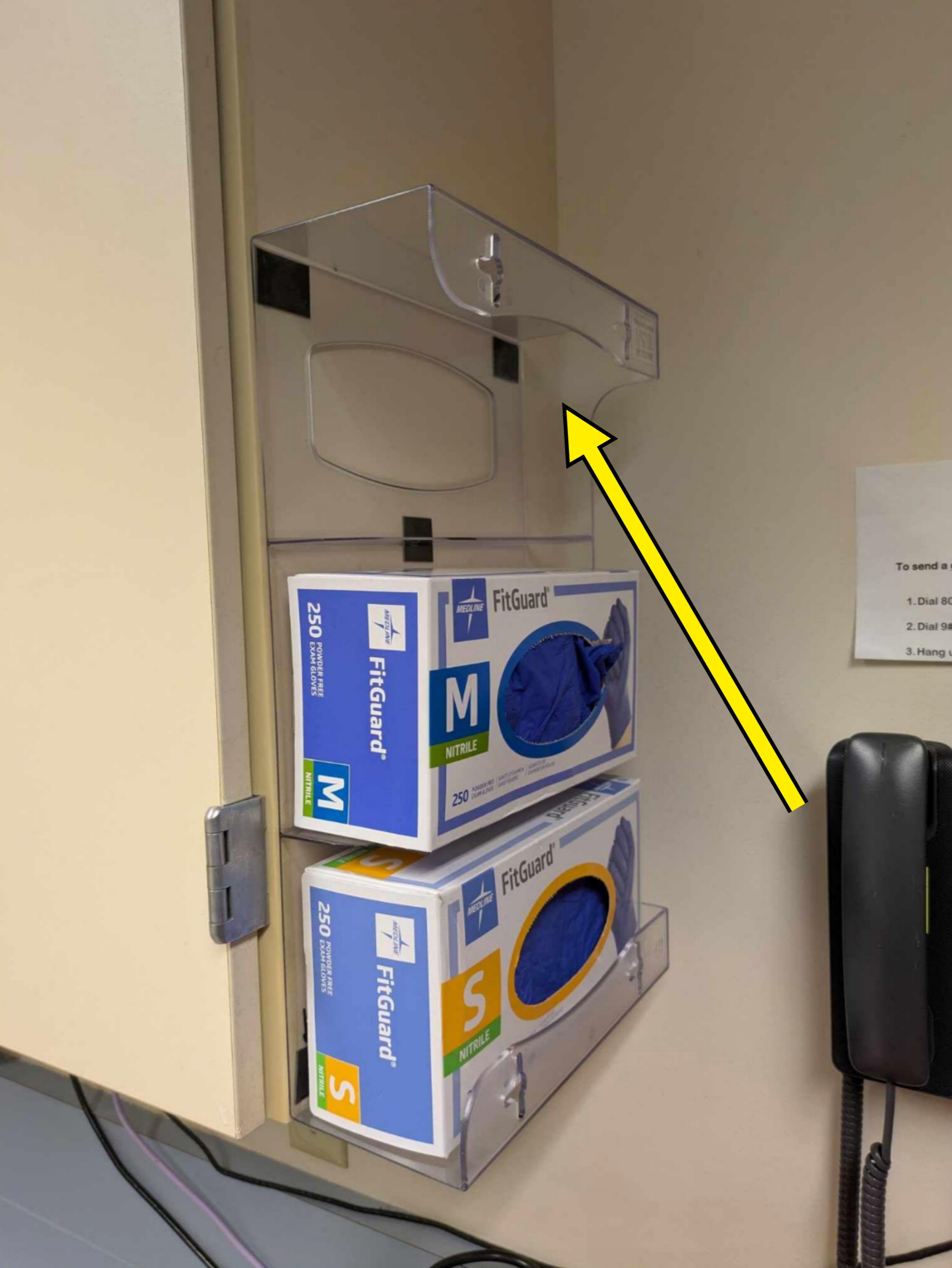 Gloves in transparent wall holders with the top one upside-down