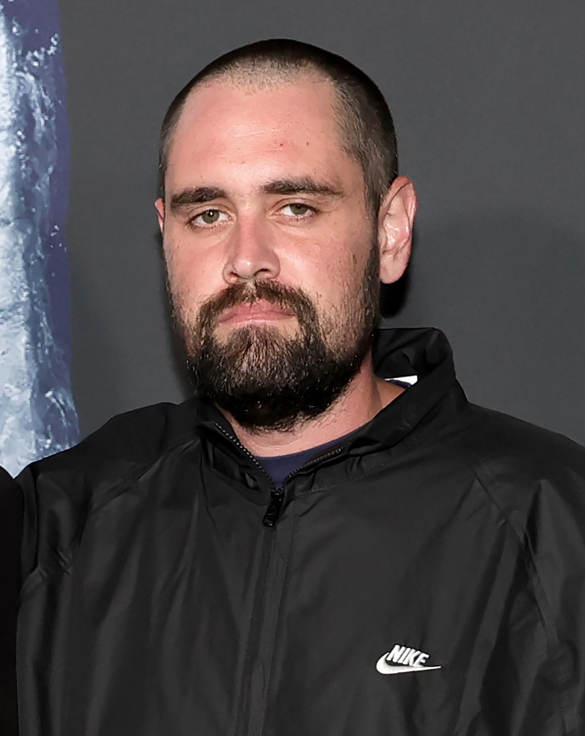 Nick Reiner med kort hår og skjegg har på seg en Nike-jakke på en salgsfremmende eller formell begivenhet