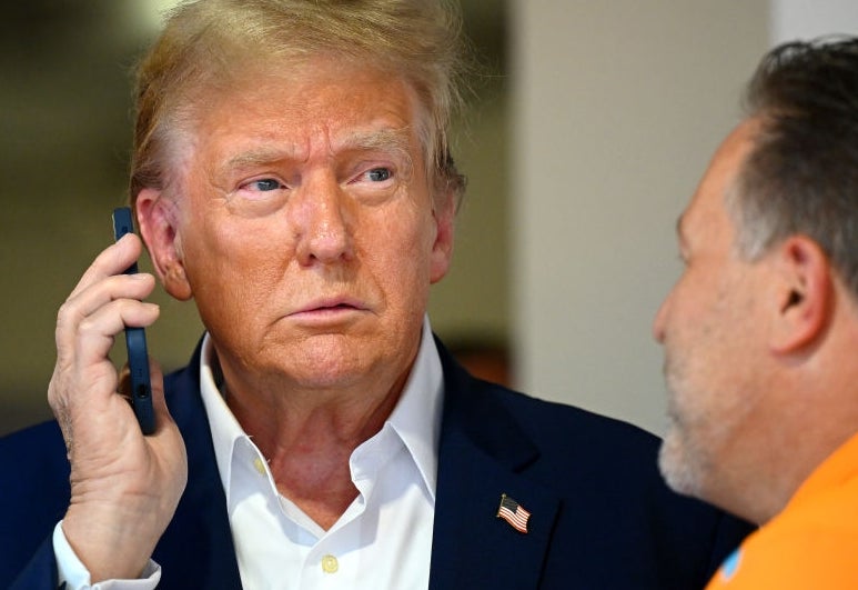 Man successful  suit   holds telephone  to receptor  portion    speaking to different  person. The mounting  appears casual