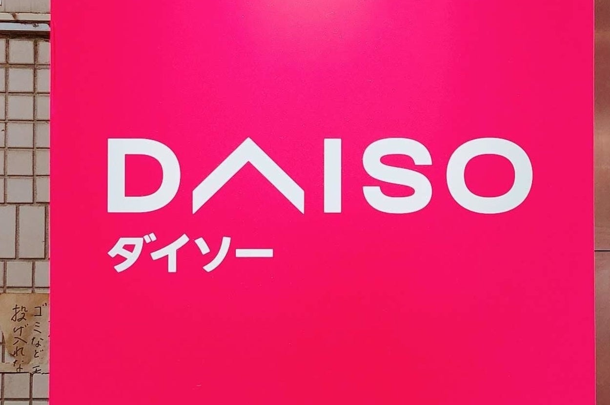 ダイソーの店舗看板。白い文字で「DAISO」と「ダイソー」と記載。