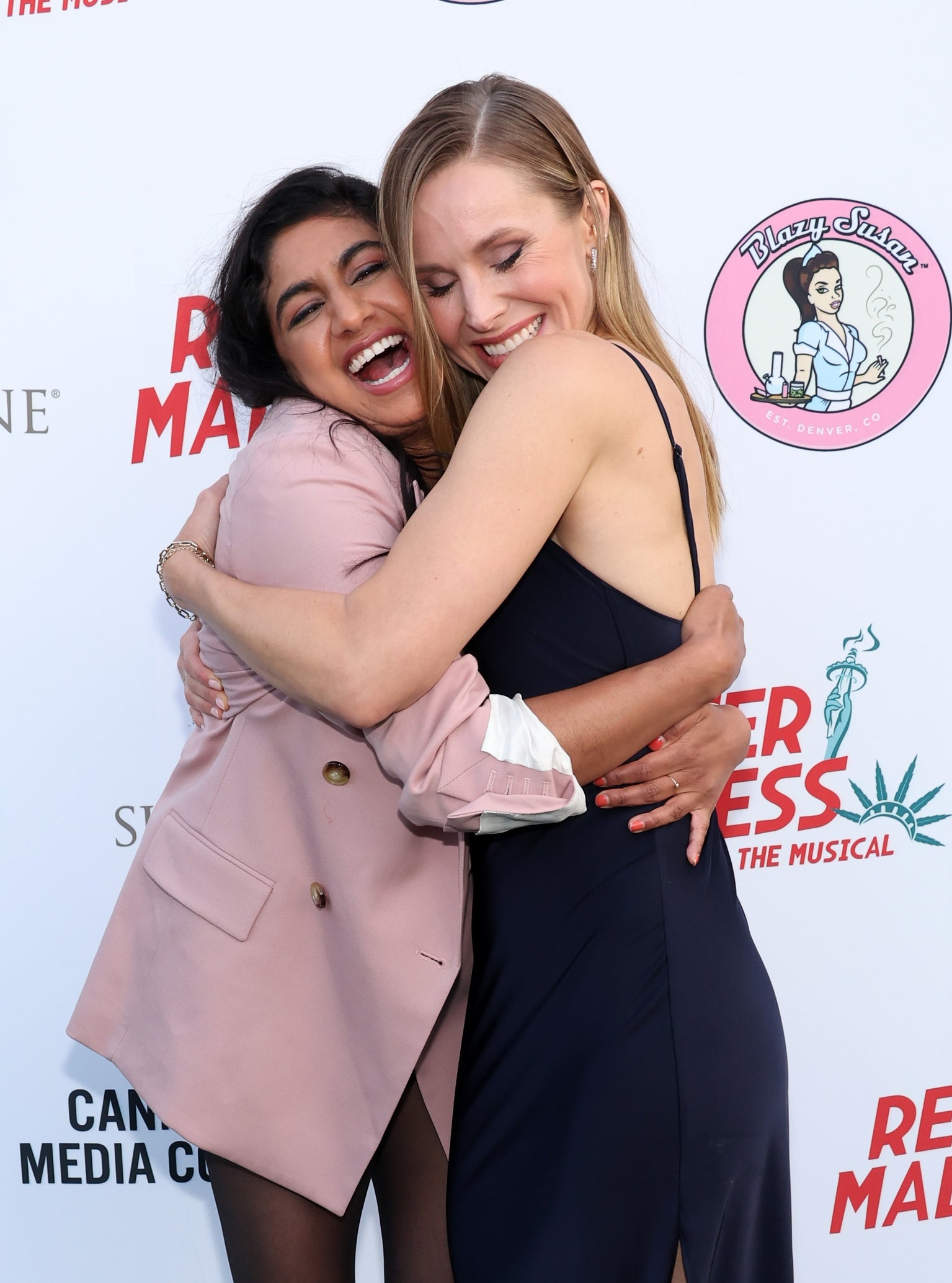 Monica and Kristen hugging and smiling astatine  a media event