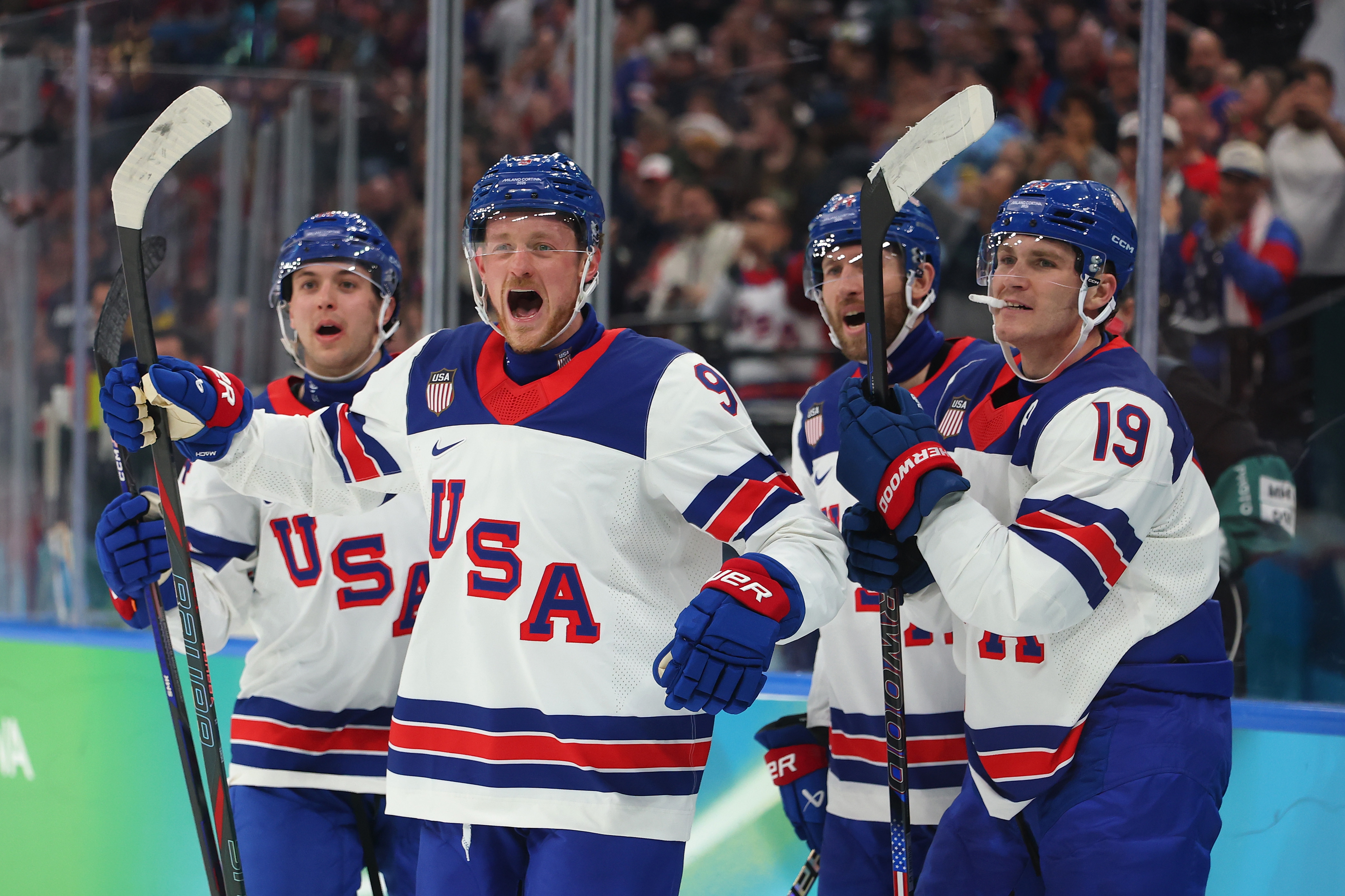 Four crystal hockey players successful achromatic USA jerseys observe connected the rink during a game, showing excitement and teamwork