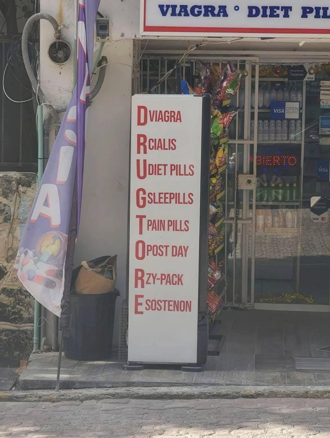 Sign outside a store listing items in vertical order, failling to spell out "Drug Tore" which should be "Drug Store" anyway; it lists: Viagra, Cialis, Diet Pills, Sleep Pills, Pain Pills, Post Day, Z-Packs, Sostenon