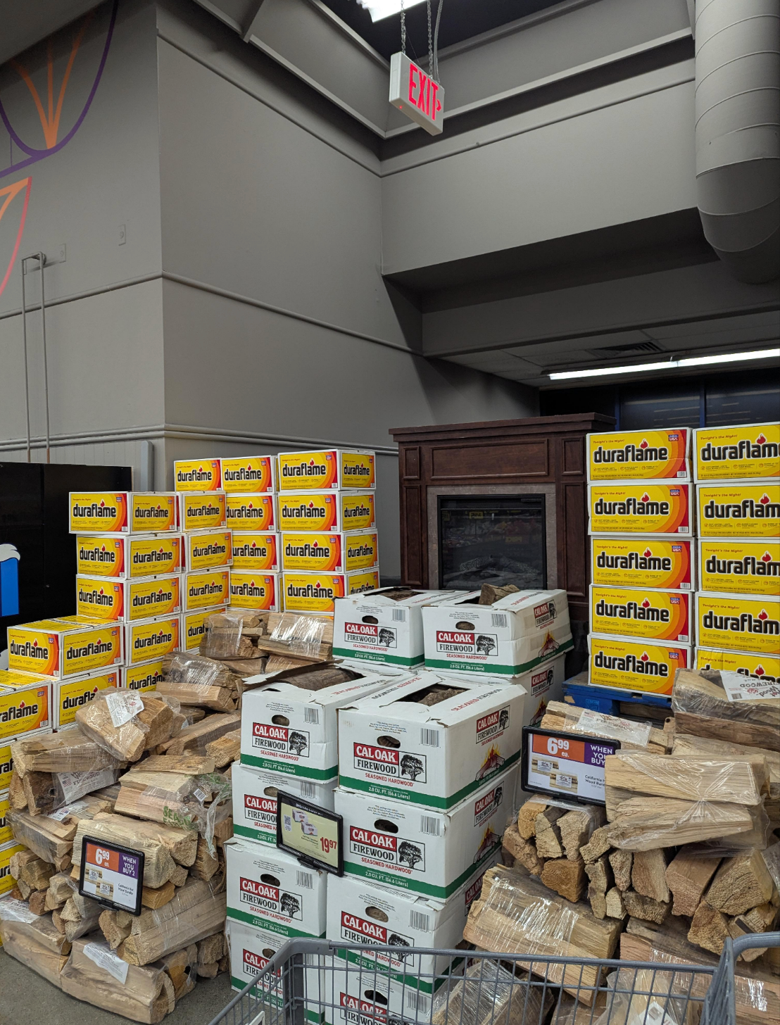 Boxes of Duraflame and Calor firelogs are stacked in front of an exit door