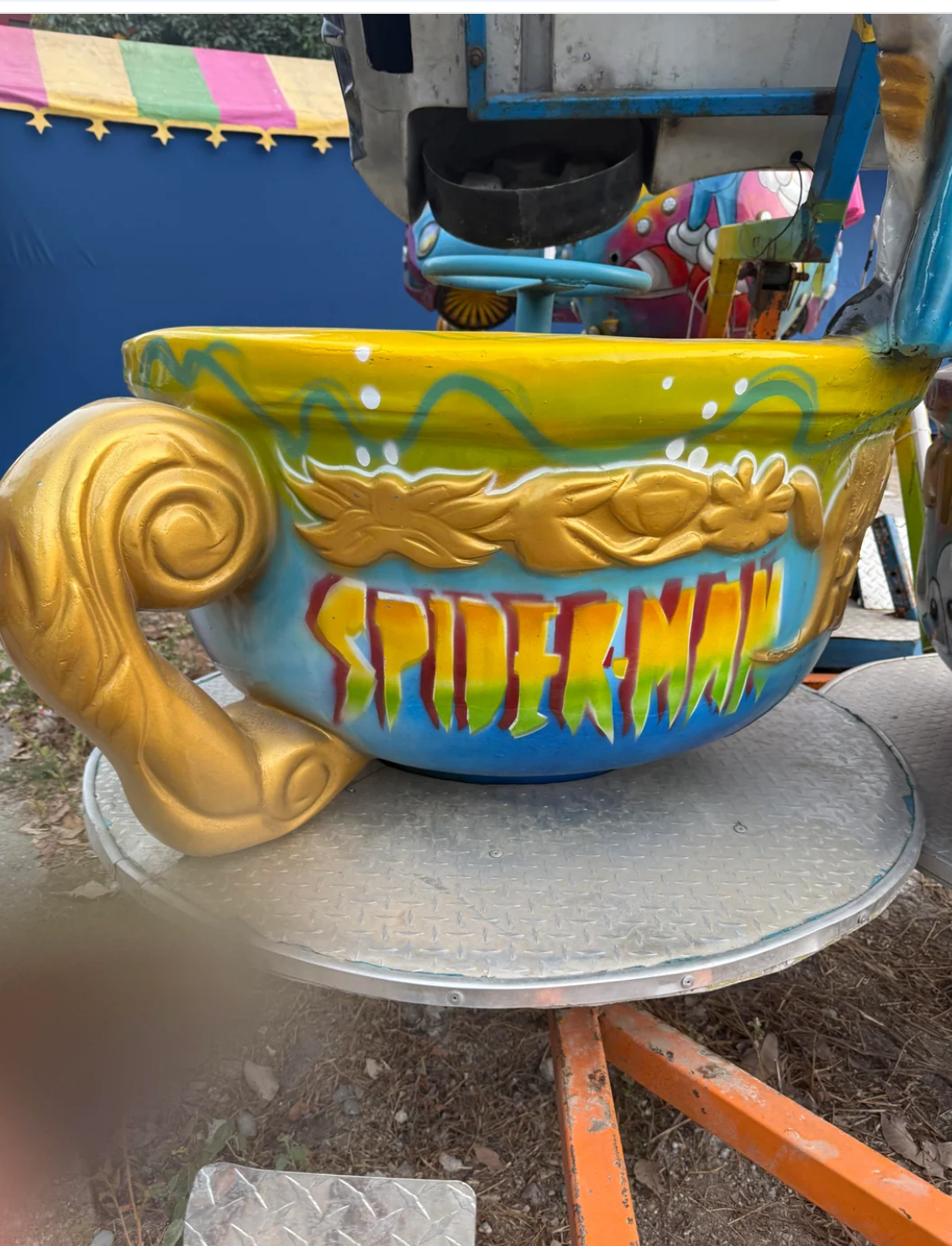Carnival ride teacup with "Spider-Man" graffiti-style text on the side