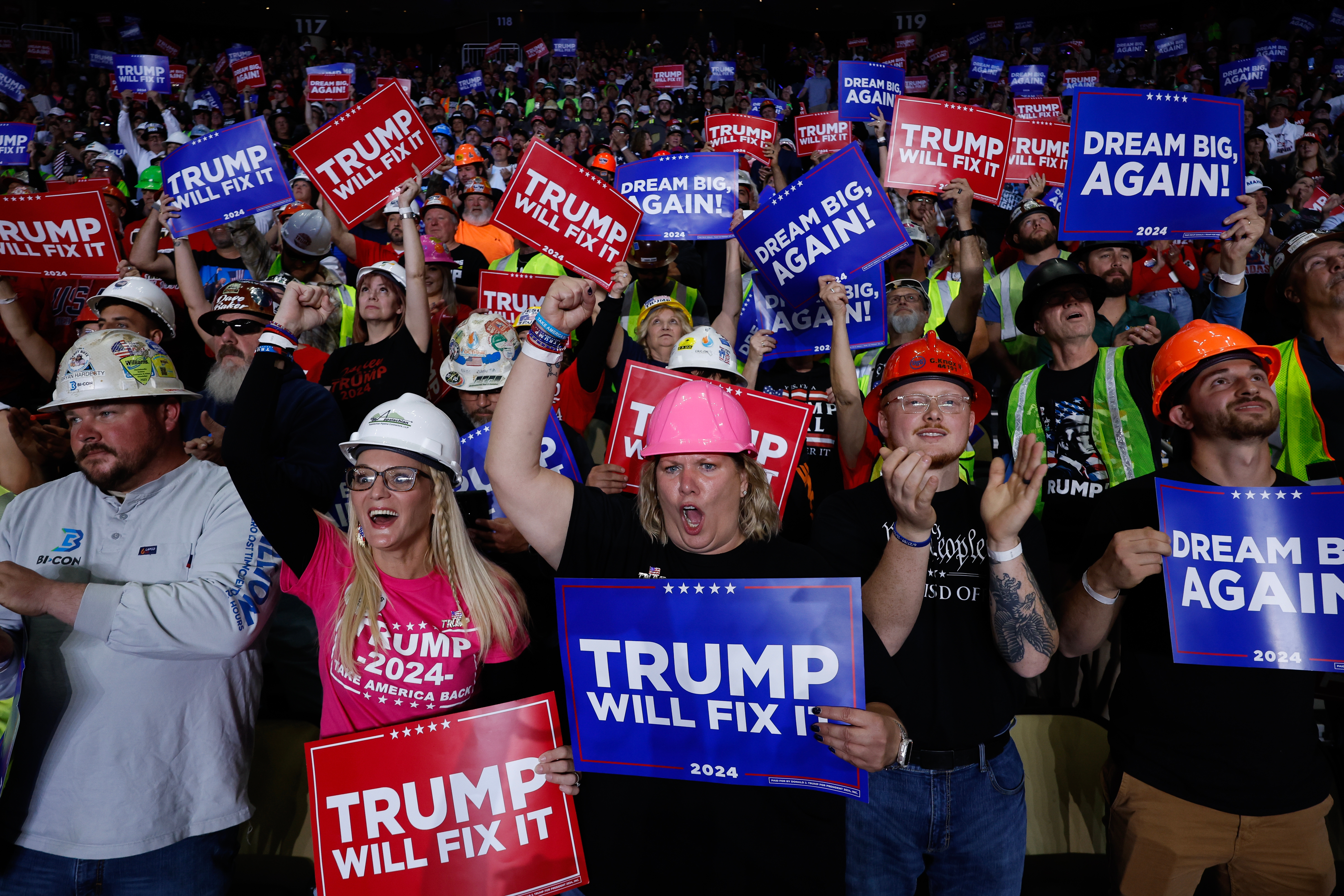 En folkemengde som holder skilt med slagord som 