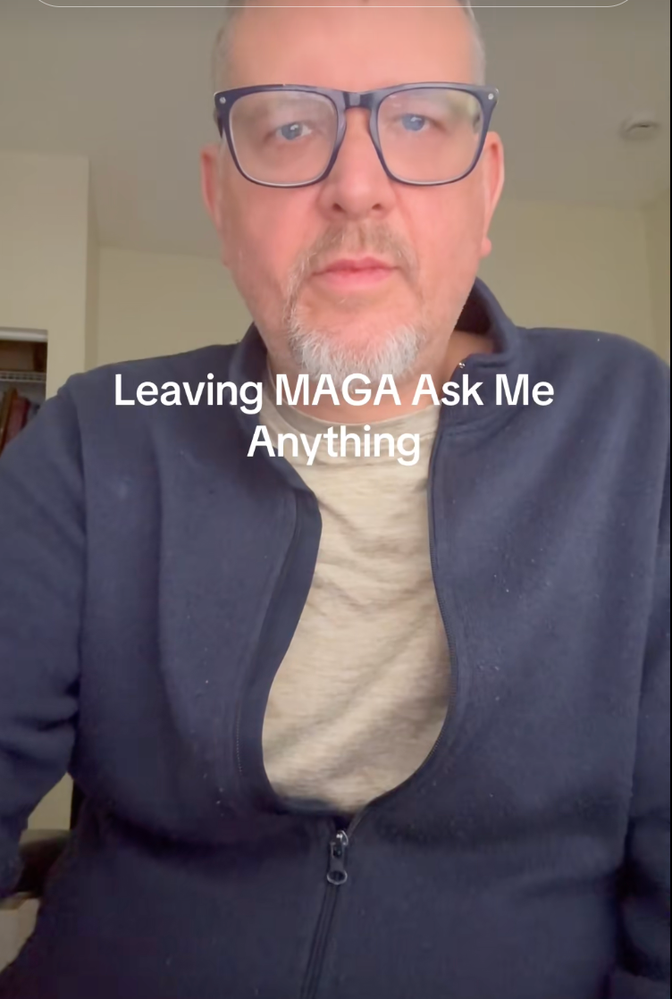 Person med briller og jakke i et rom, som presenterer en video med tittelen 