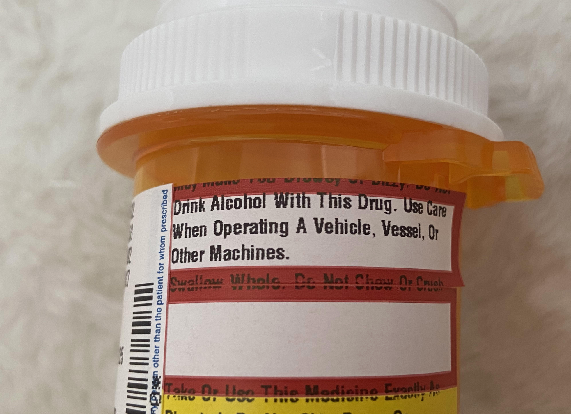 Prescription bottle close-up with warnings: "Drink alcohol with this drug"