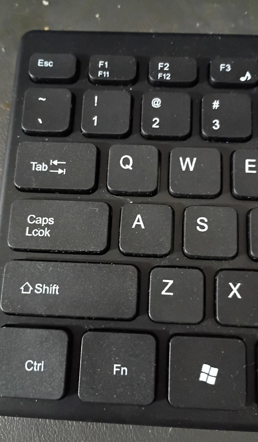 Close-up of a keyboard, focusing on the Caps Lock, spelled "Caps Lcok"