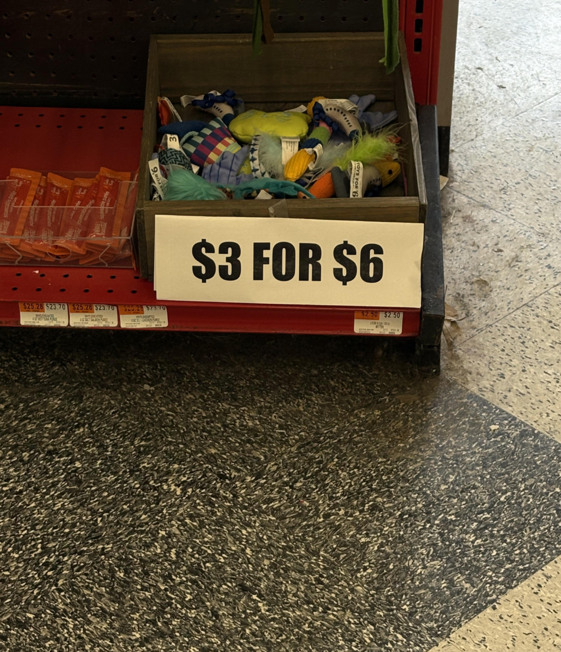 Store display of dog toys marked with a sign reading "$3 for $6."