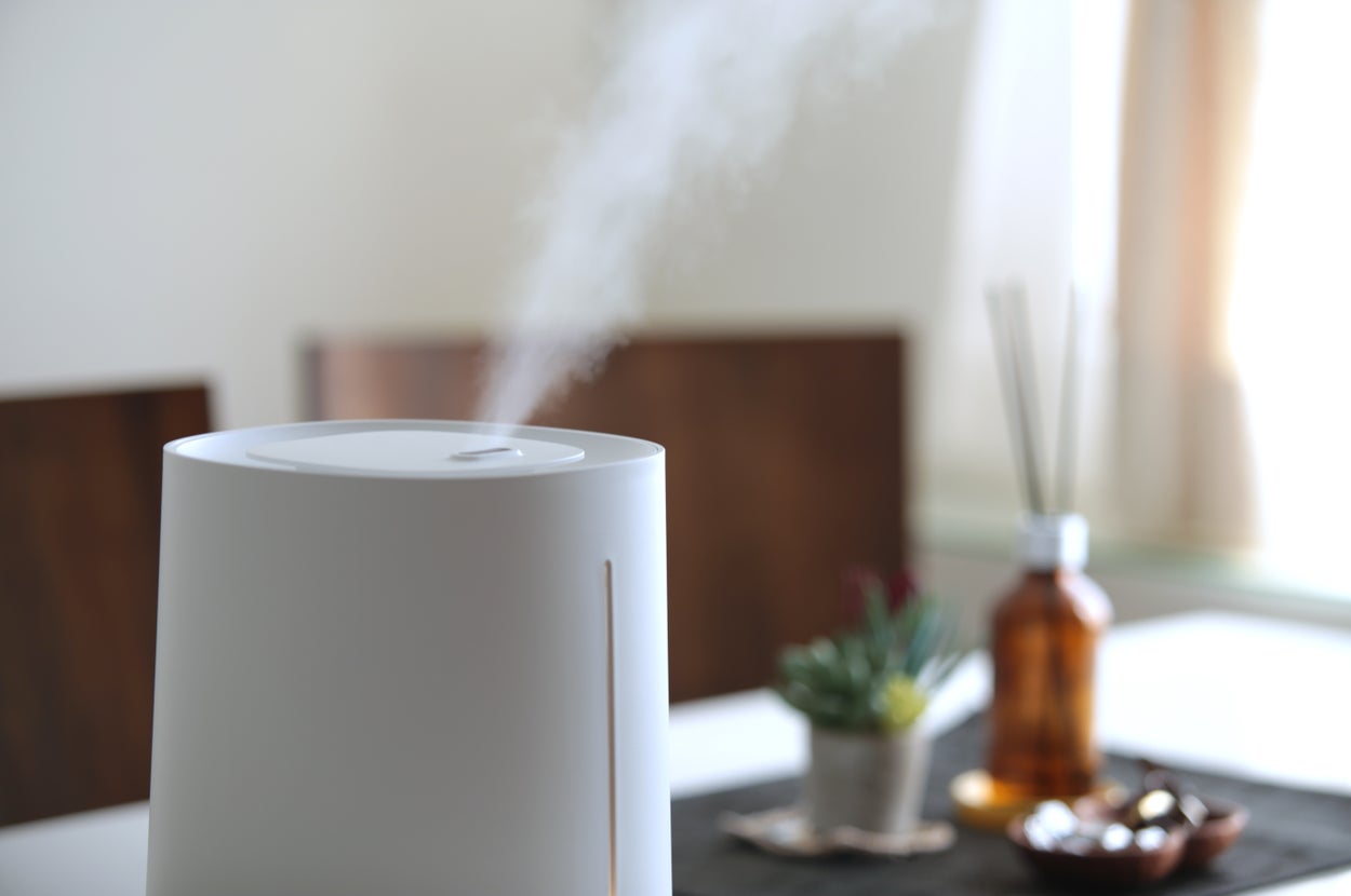 部屋で稼働中の加湿器。背景にはテーブルと装飾品が見える。