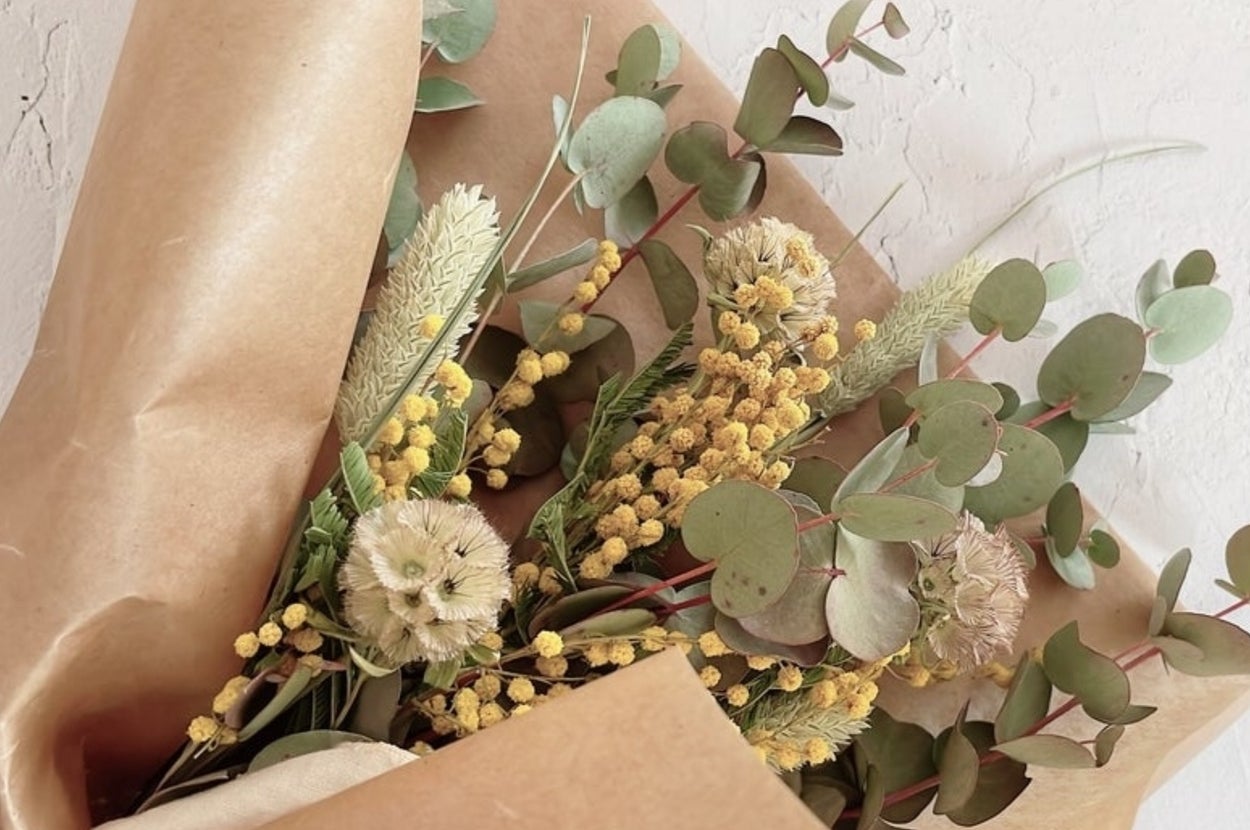 茶色の紙で包まれたミモザのドライフラワーブーケ