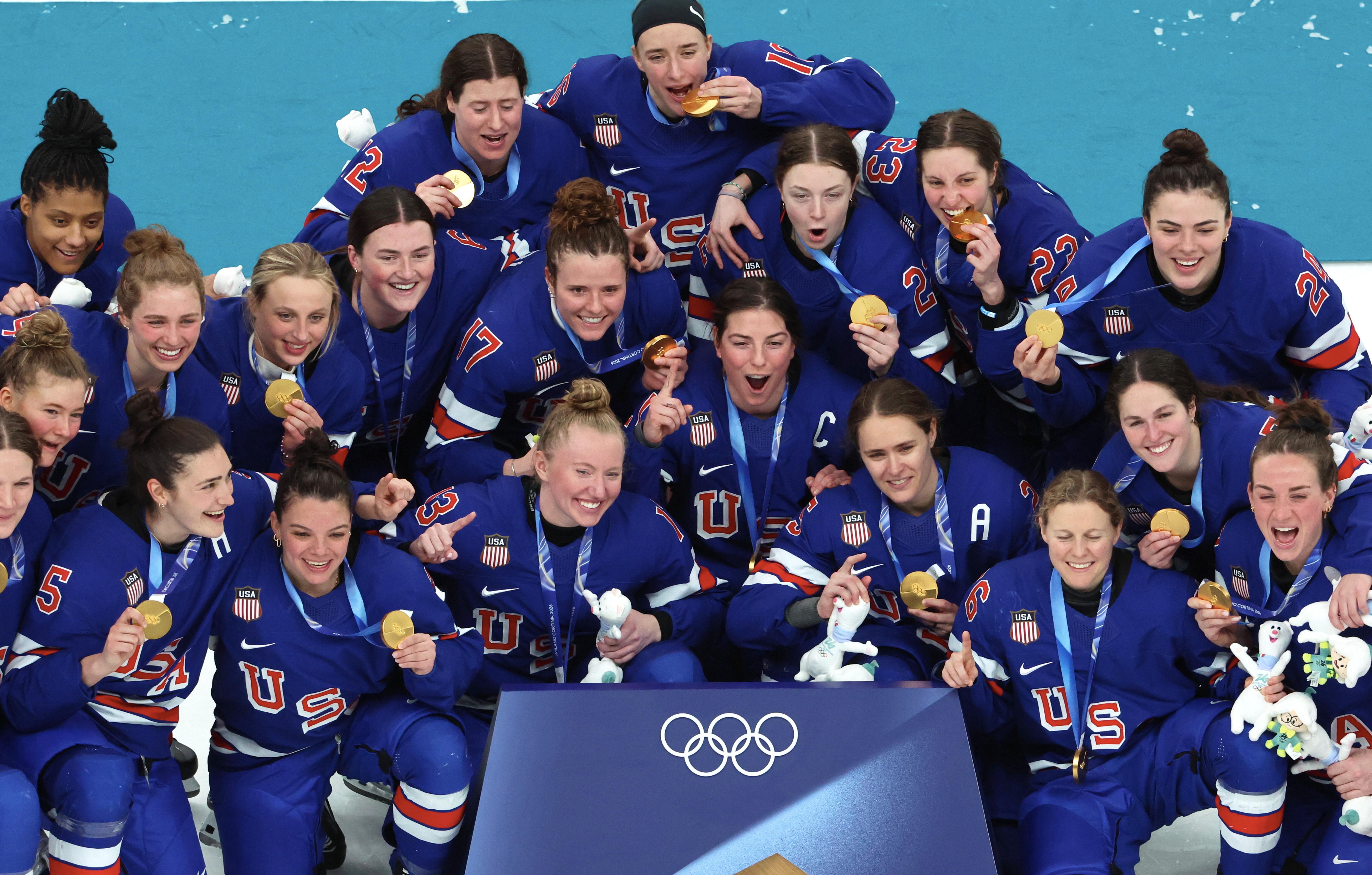 Team USA kvinnehockey feirer med gullmedaljer ved OL, smiler og poserer sammen i uniformer