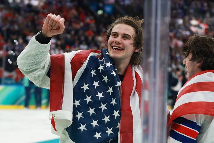 Athlete celebrates with a jubilant expression, draped successful  an American flag, aft  a sporting lawsuit   victory