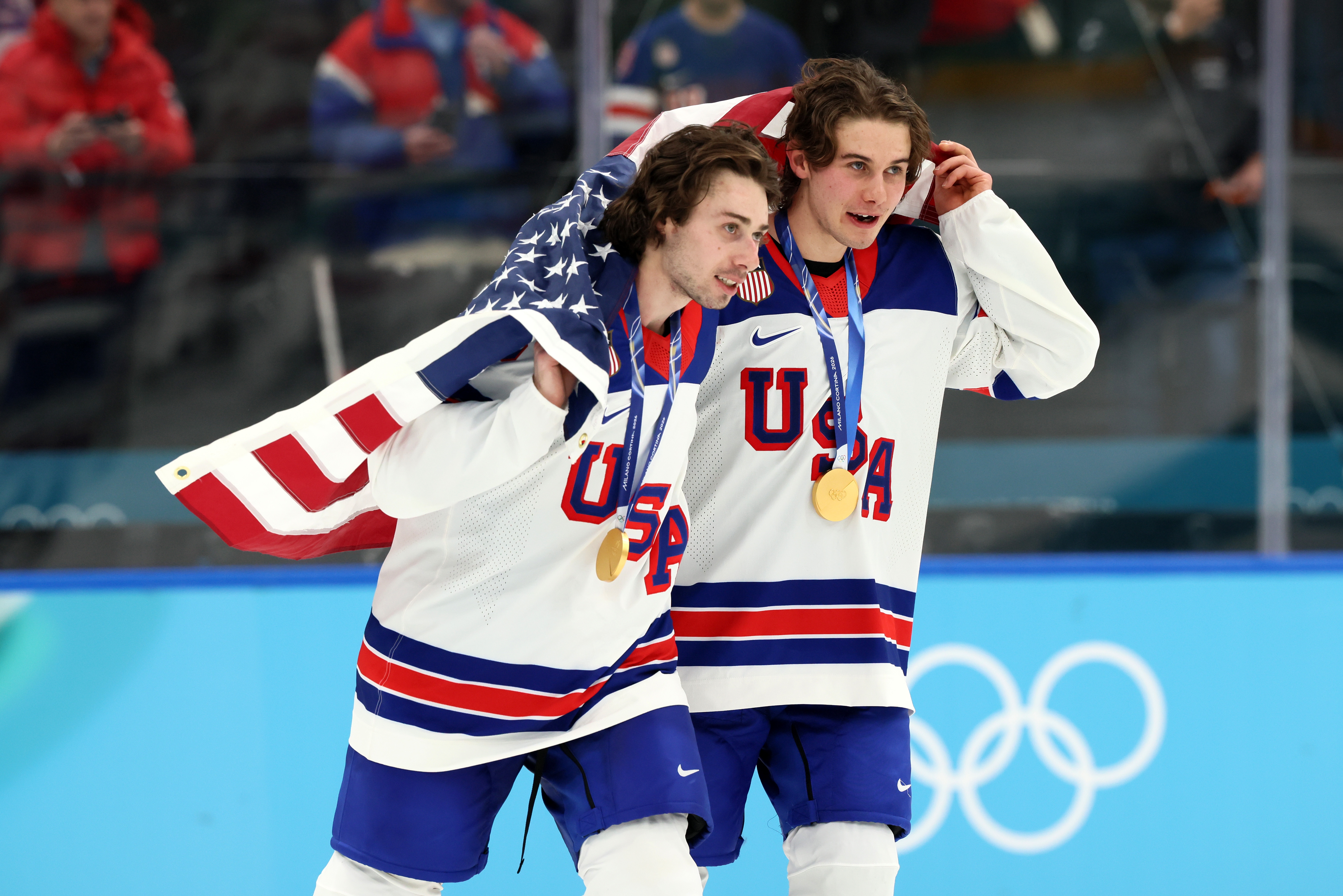 Two crystal  hockey players successful  USA jerseys observe  with golden  medals and a draped American emblem  astatine  the Olympics