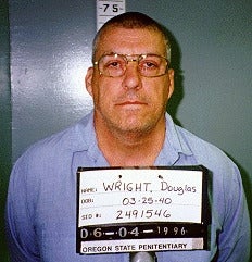 Person in prison uniform holding an identification board with personal details and prison information