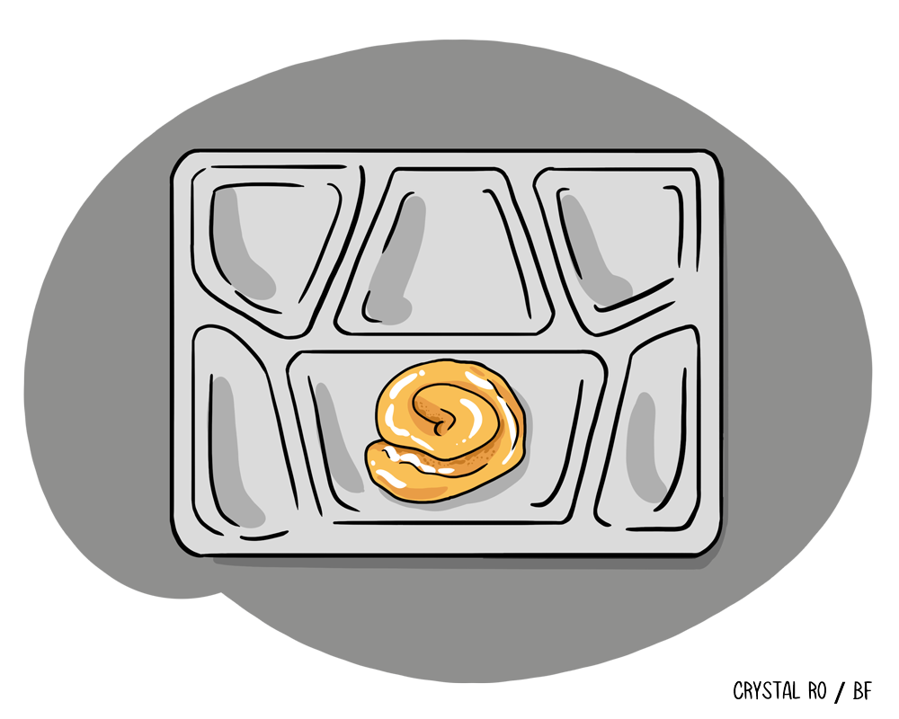 A single sweet roll on a mostly empty cafeteria tray