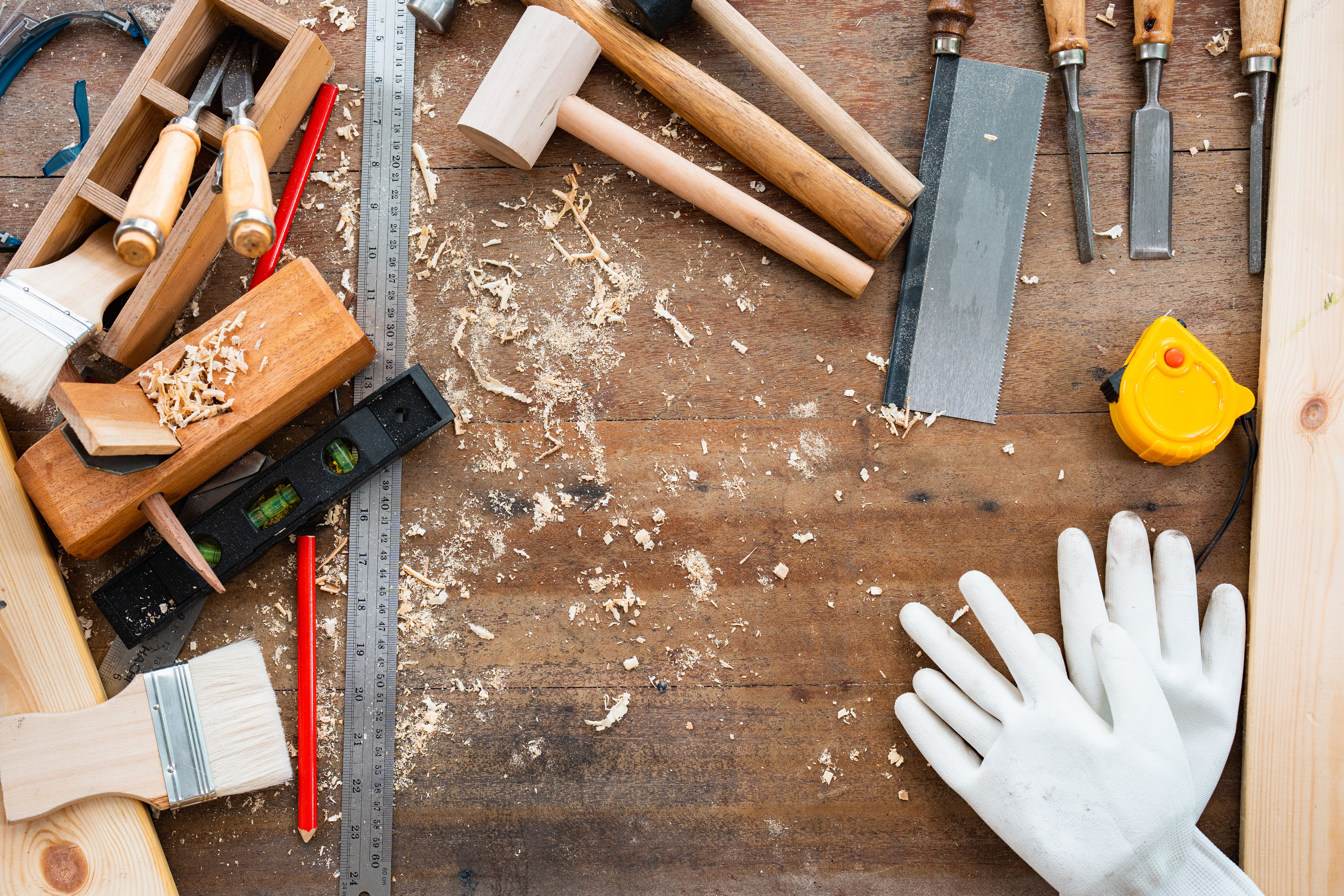 Woodworking tools and gloves are arranged connected a workbench