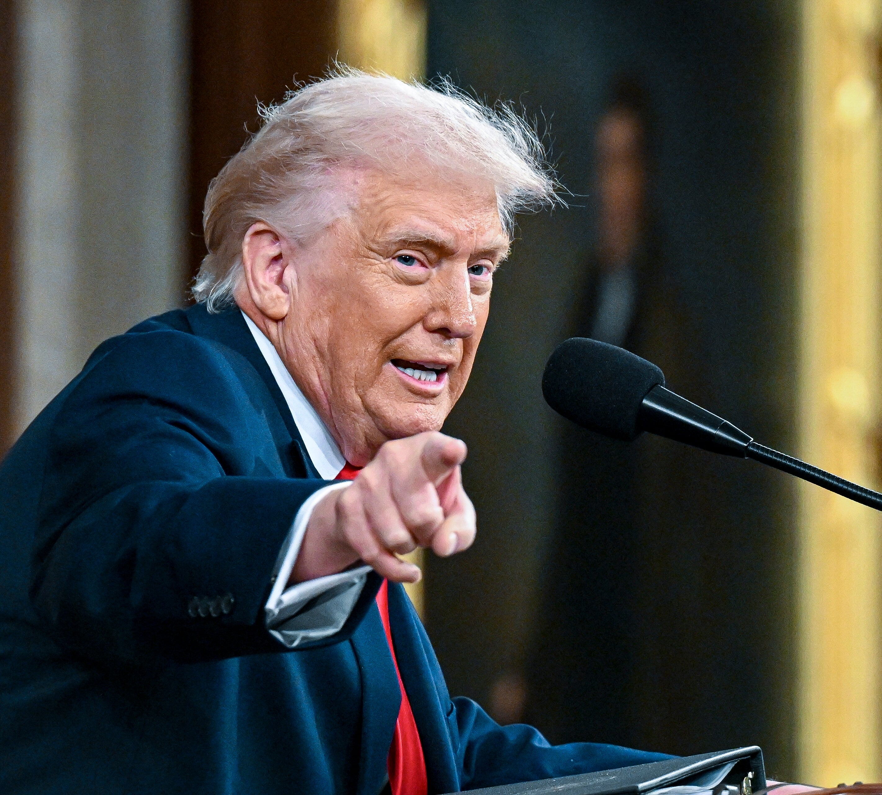 Trump ved et podium og gestikulerer mens han snakker
