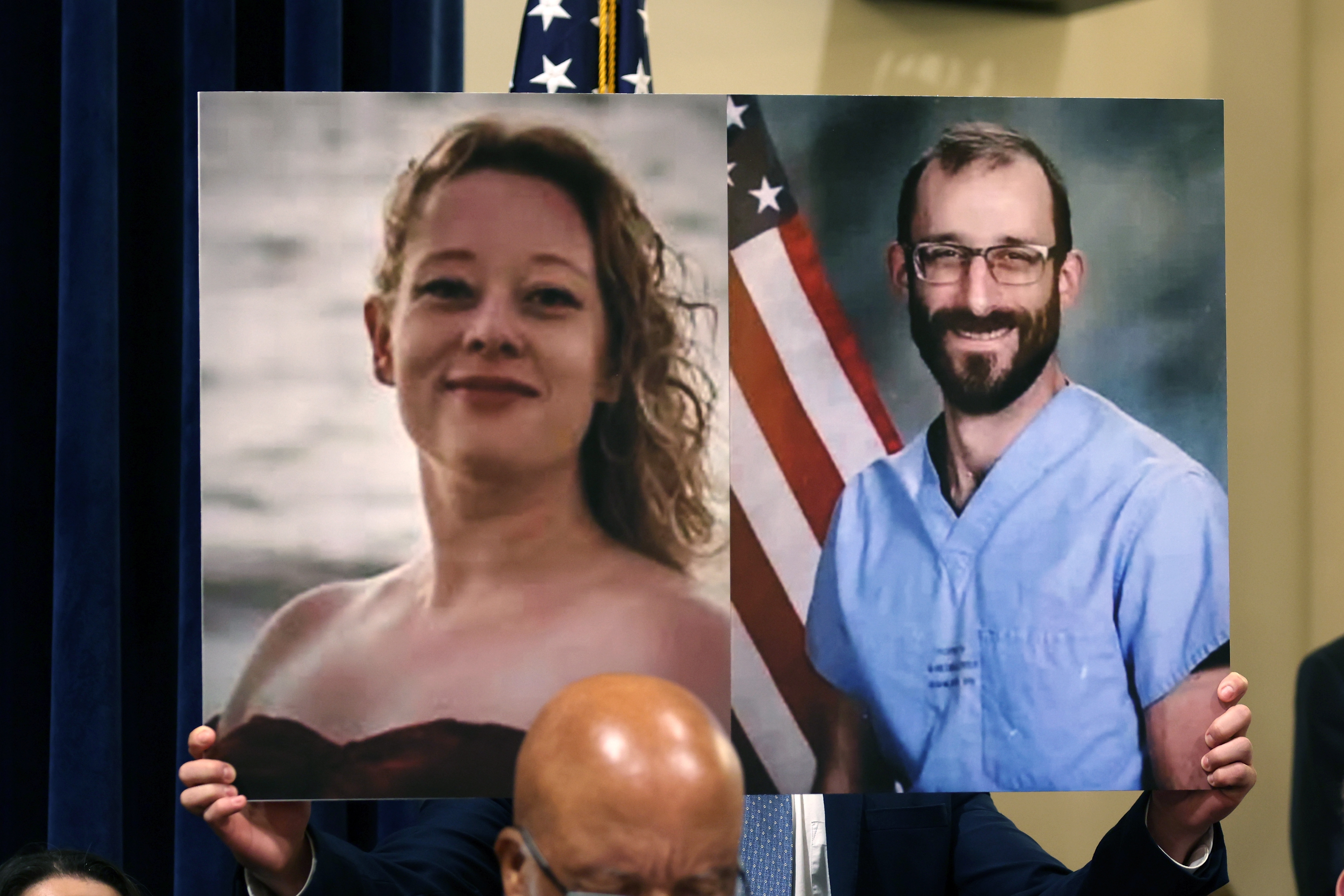 En person holder en stor tavle som viser to portrettbilder: en kvinne ved sjøen og en mann i medisinsk scrubs foran et flagg