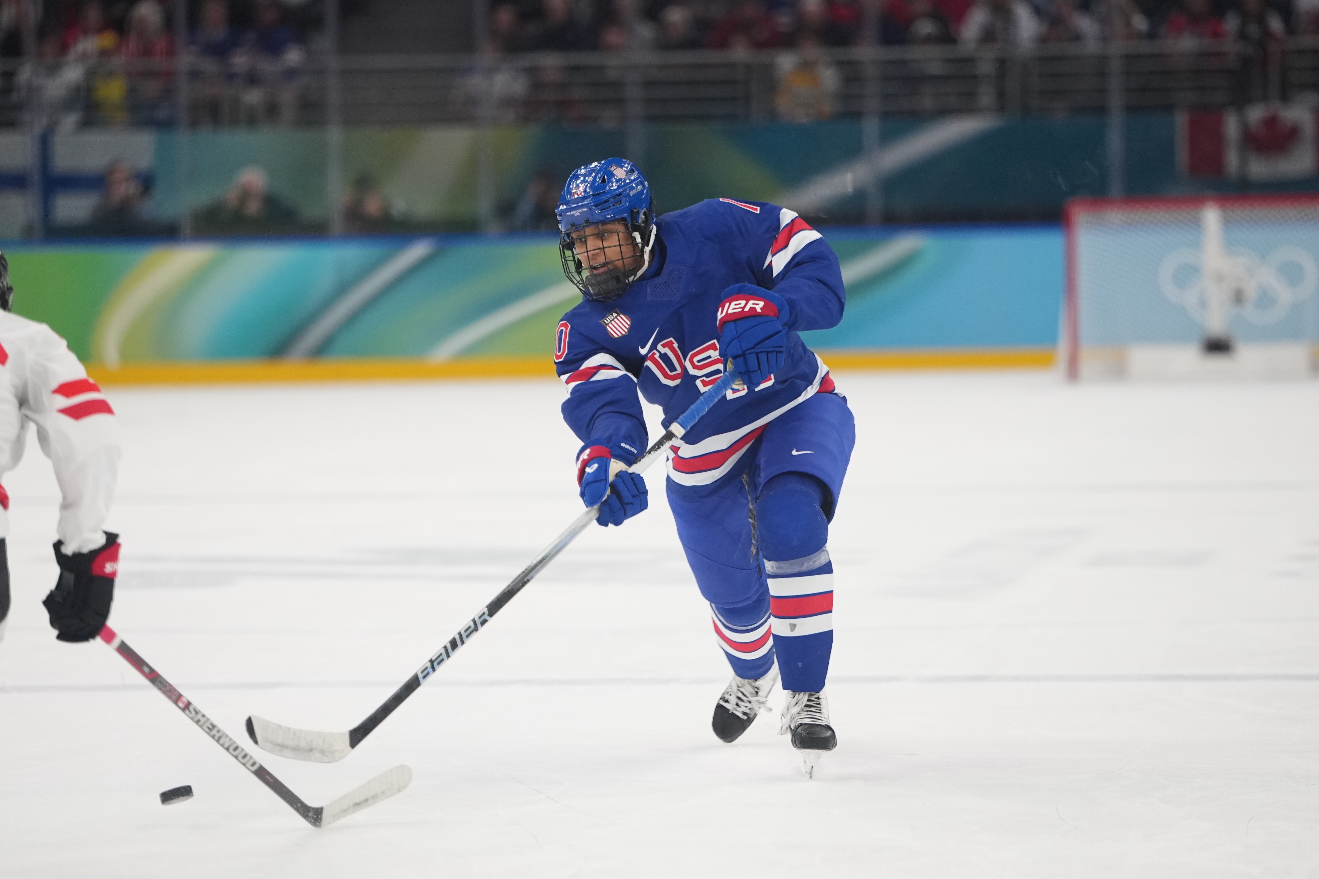 Hockey player Laila Edwards in USA gear skating on ice