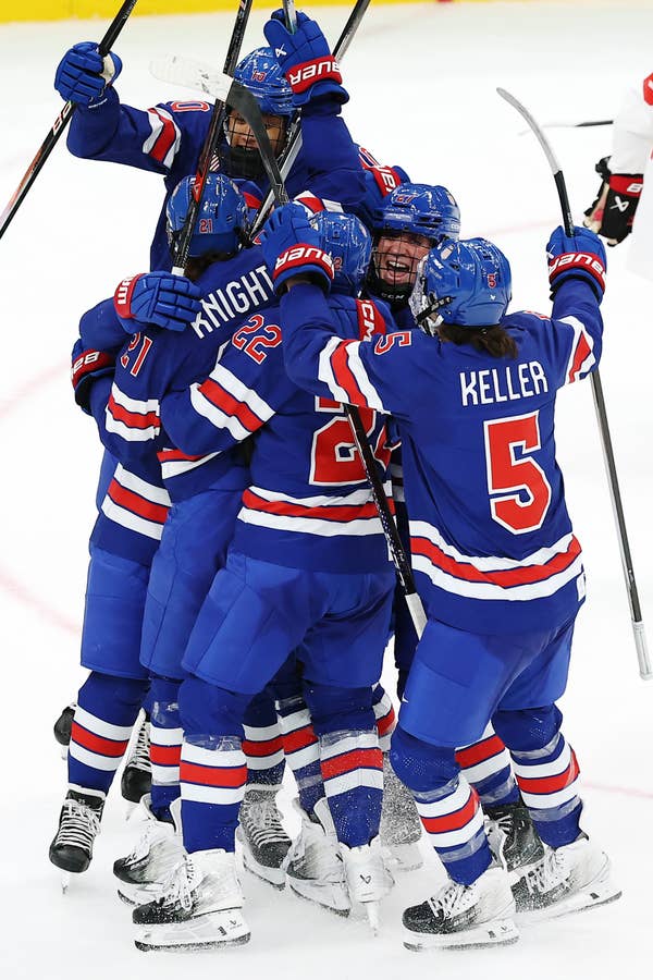 Hockey team in blue jerseys celebrate on ice