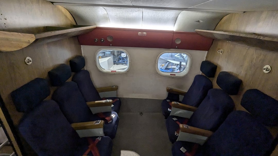 Vintage airplane compartment  interior with rows of navy bluish  seats and tiny  windows