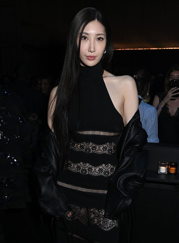 Person successful elegant achromatic lace evening formal and leather overgarment astatine a personage event, posing confidently for the camera