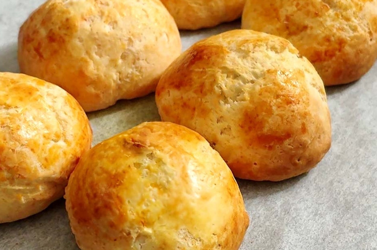 ベーキングシートの上に並べられた6個の焼きたてのパン。