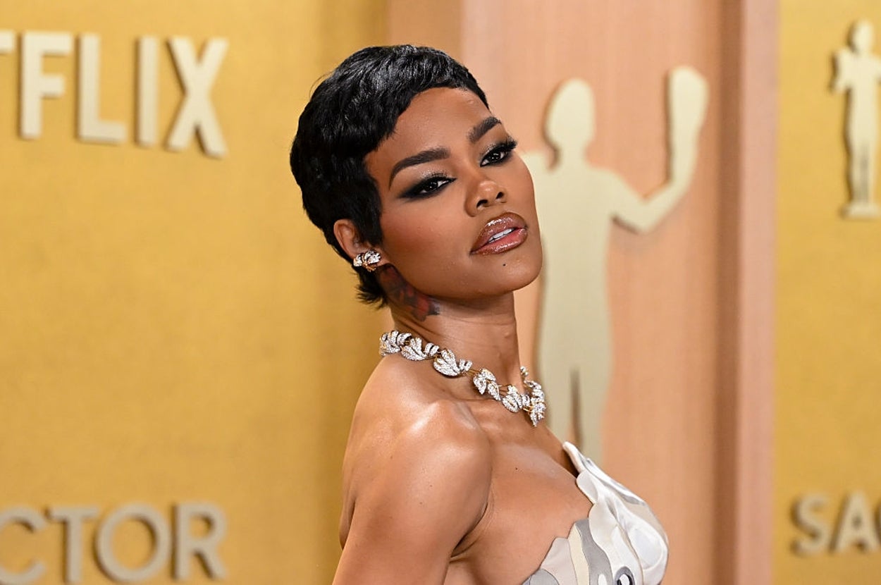 女性がイベントで豪華なイヤリングとネックレスを身に着け、エレガントなドレスを着ています。