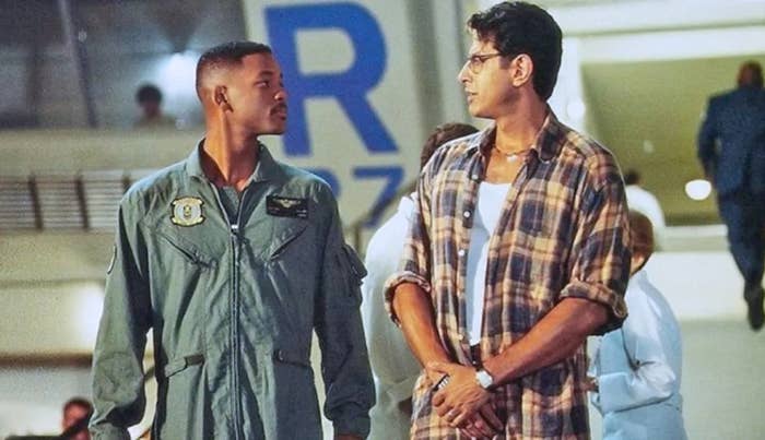 Two men basal   broadside  by side; 1  successful  a subject   formation  suit   and the different   successful  a casual plaid shirt, looking astatine  each   other