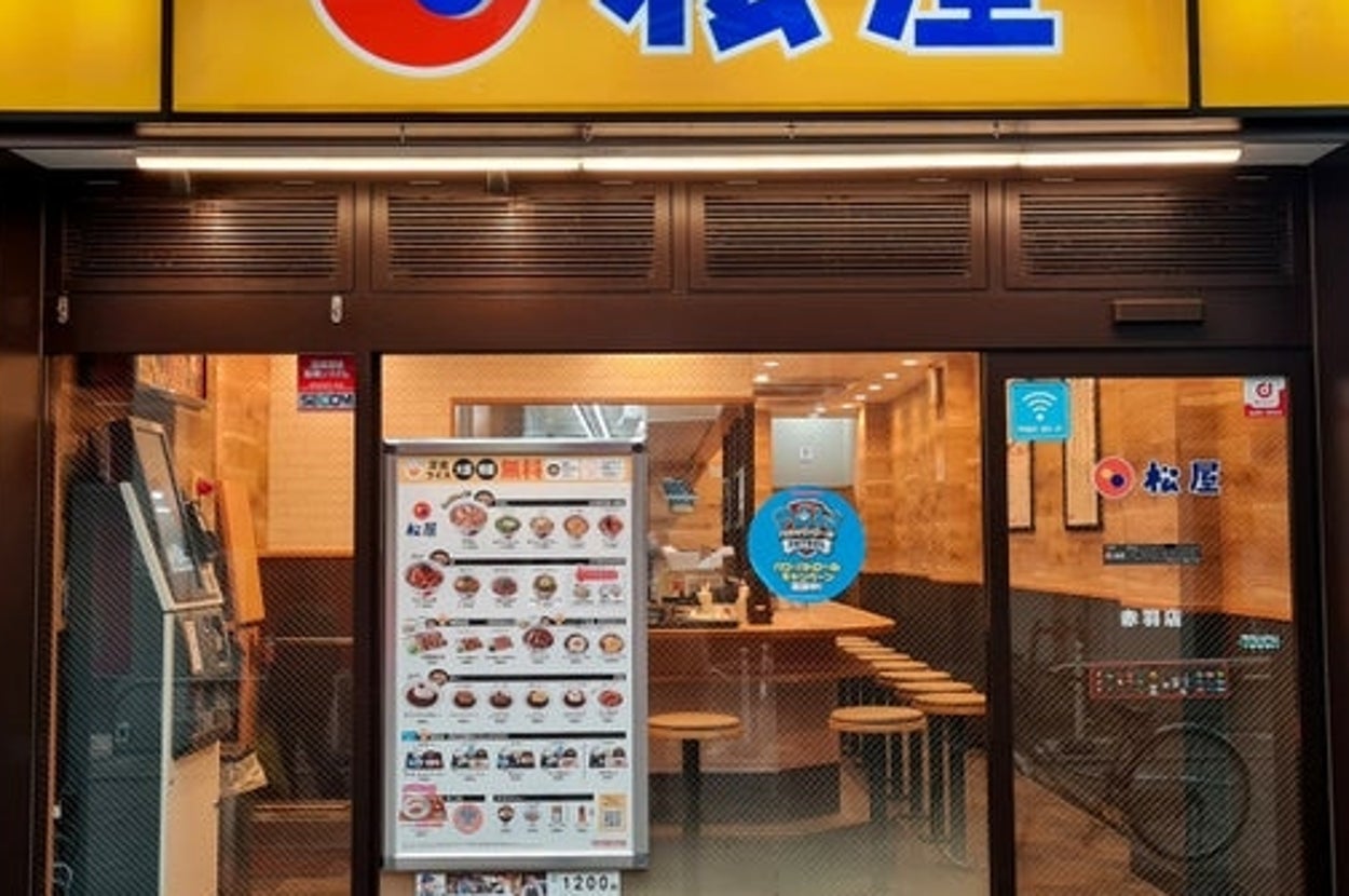 松屋の店舗外観。メニューが窓に掲示されており、店内にカウンター席が並んでいる。