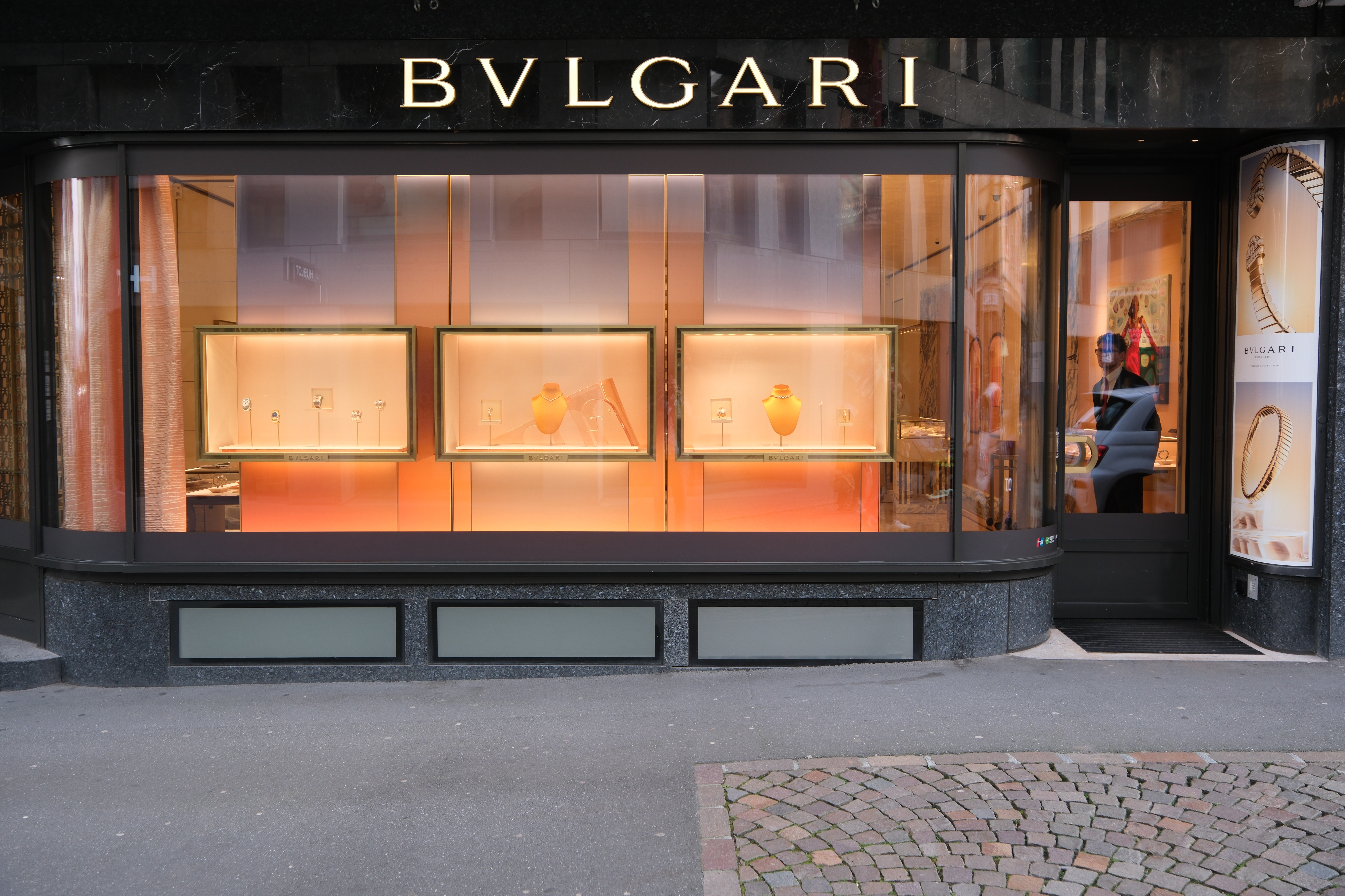 ブルガリの店頭ディスプレイ。いくつかのジュエリーが展示されており、ショーウィンドウに照明が当たっている。