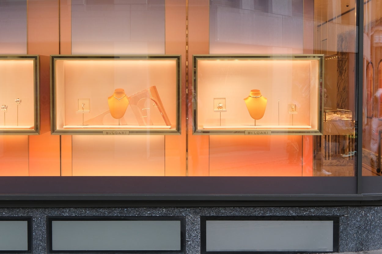 ブルガリの店頭ディスプレイ。いくつかのジュエリーが展示されており、ショーウィンドウに照明が当たっている。