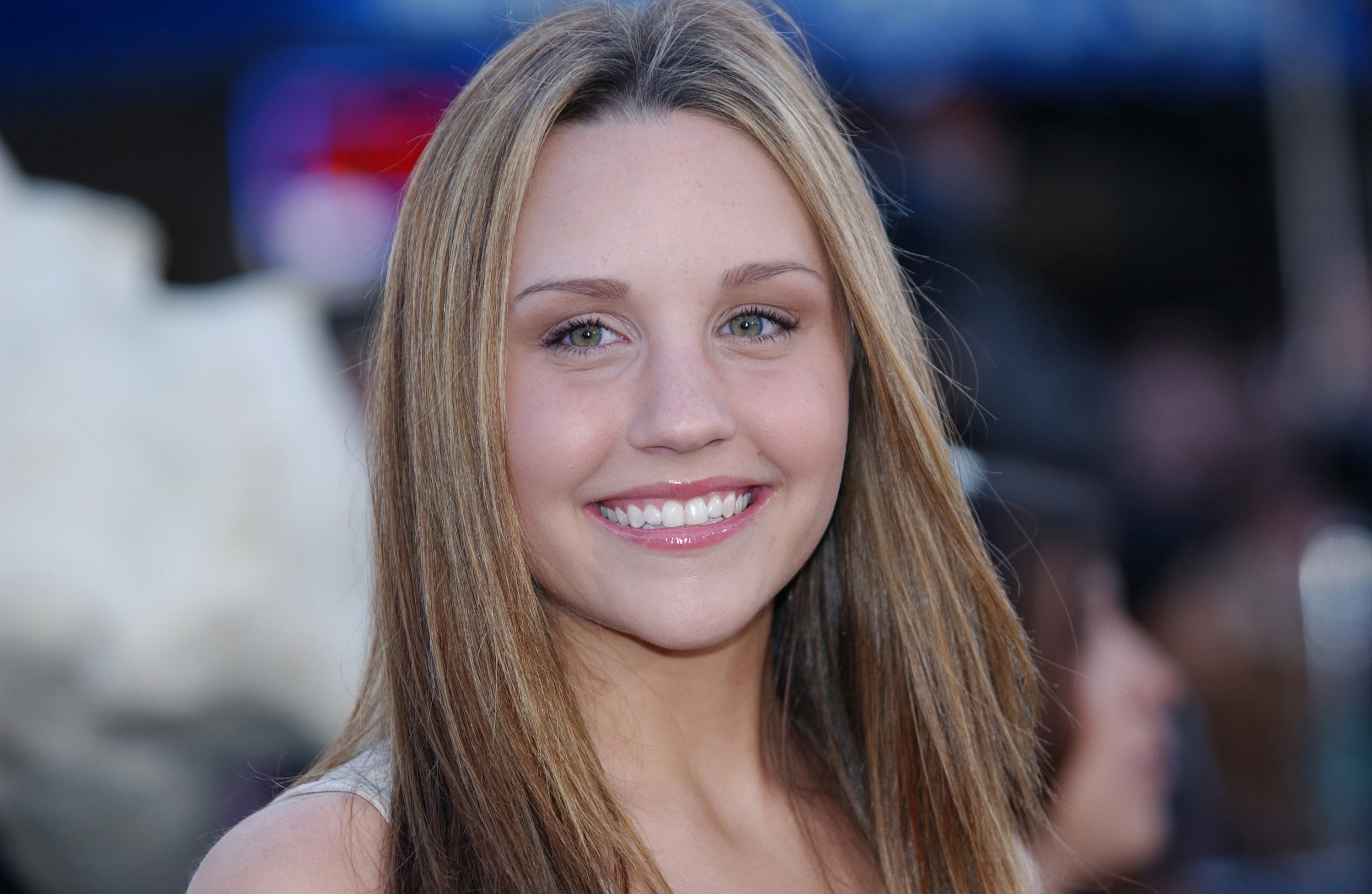 Amanda Bynes with long straight hair at an event. Neutral background