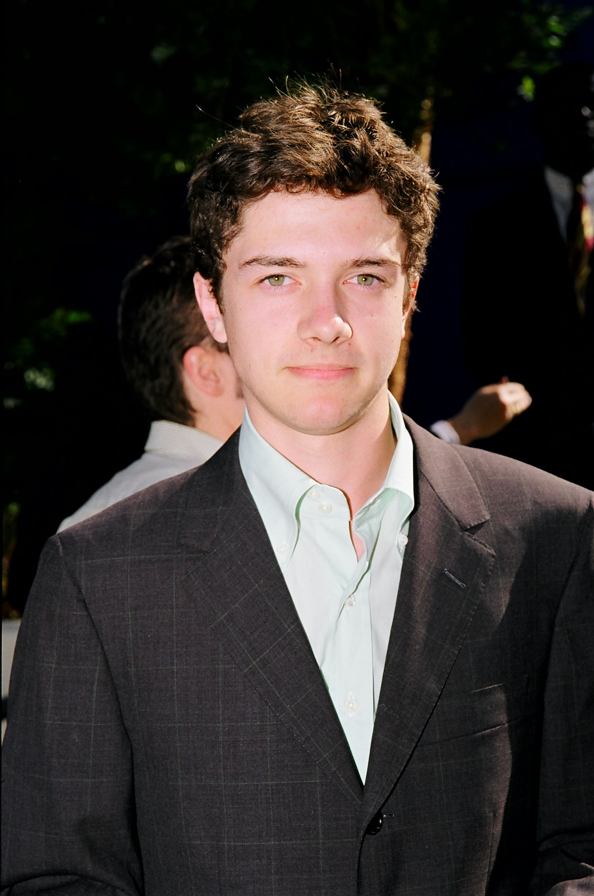Topher Grace wearing a suit over a dress shirt is on a formal occasion