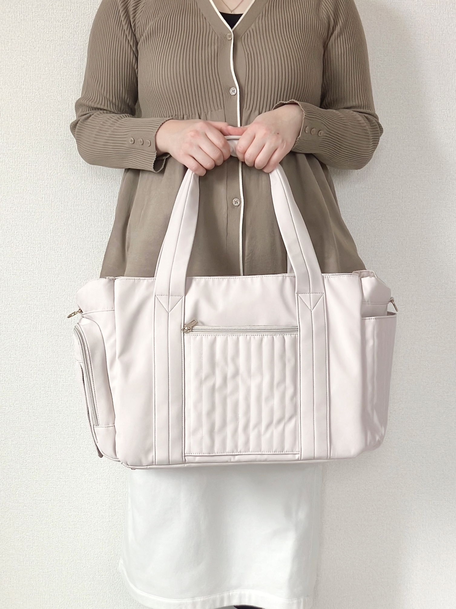 WORKMAN（ワークマン）の「マザーズ機能が全部盛り！ファミリーライフボストンバッグ」人物が大きなトートバッグを持っている様子。シンプルで機能的なデザイン。