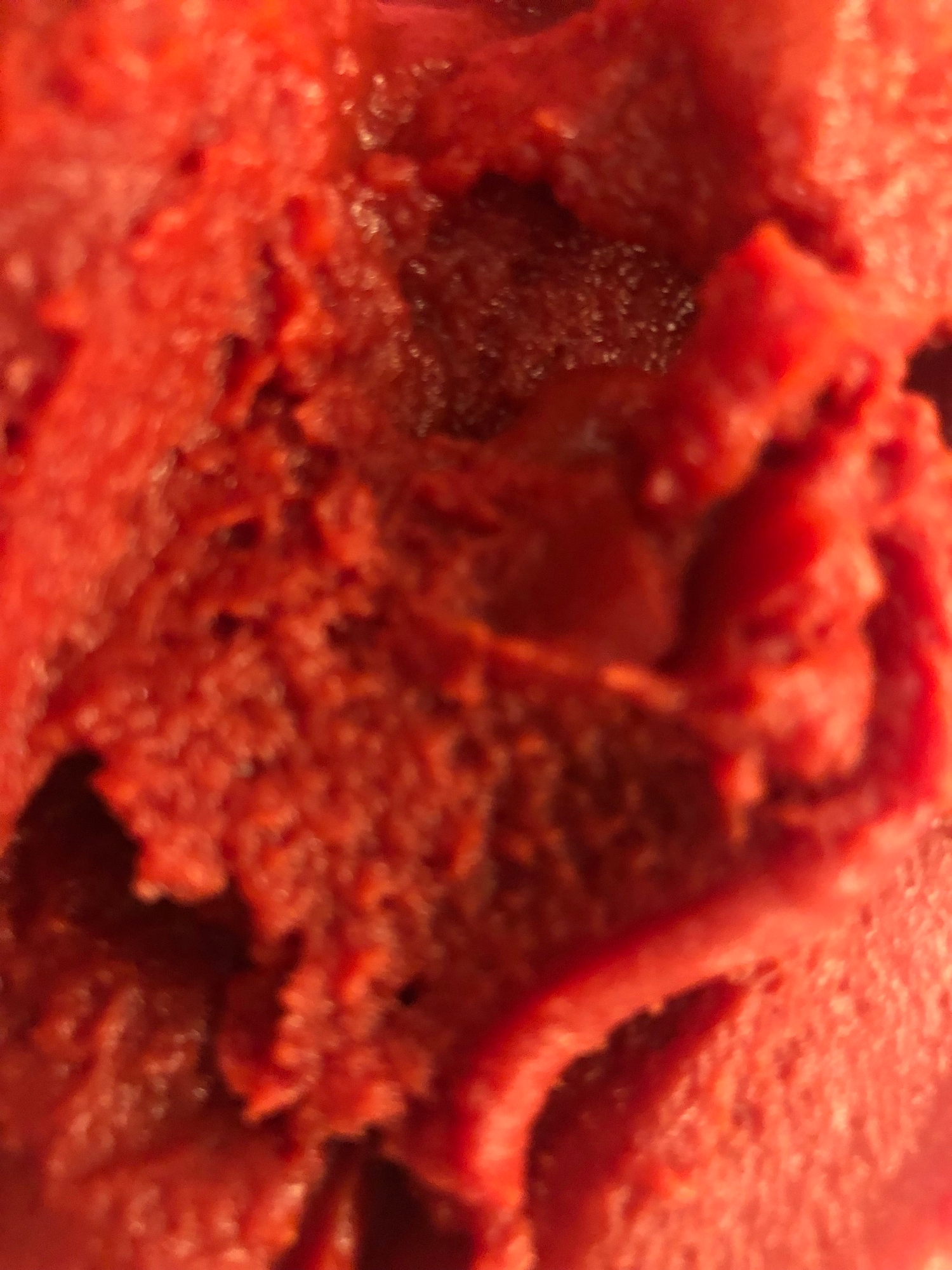 Close-up of a textured reddish  substance, perchance  a nutrient  point  similar  sorbet oregon  gelato, showing details of its aboveground  and consistency