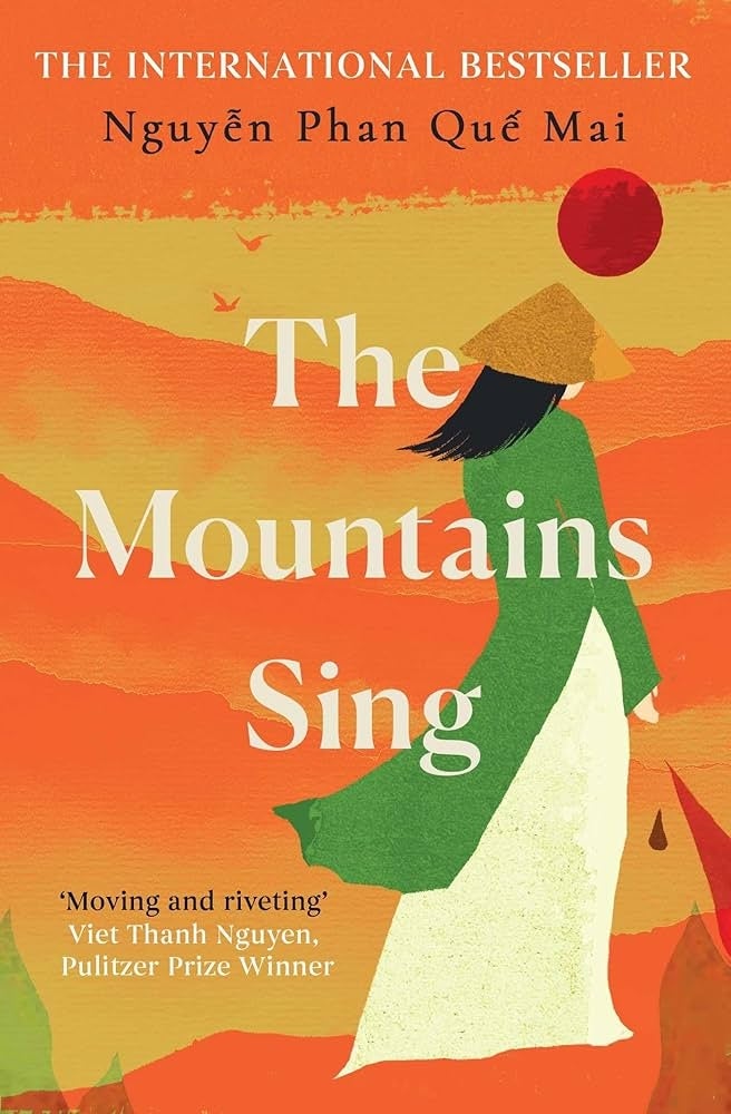 Book cover of "The Mountains Sing" by Nguyễn Phan Quế Mai, featuring a figure in a conical hat against stylized mountains and a red sun