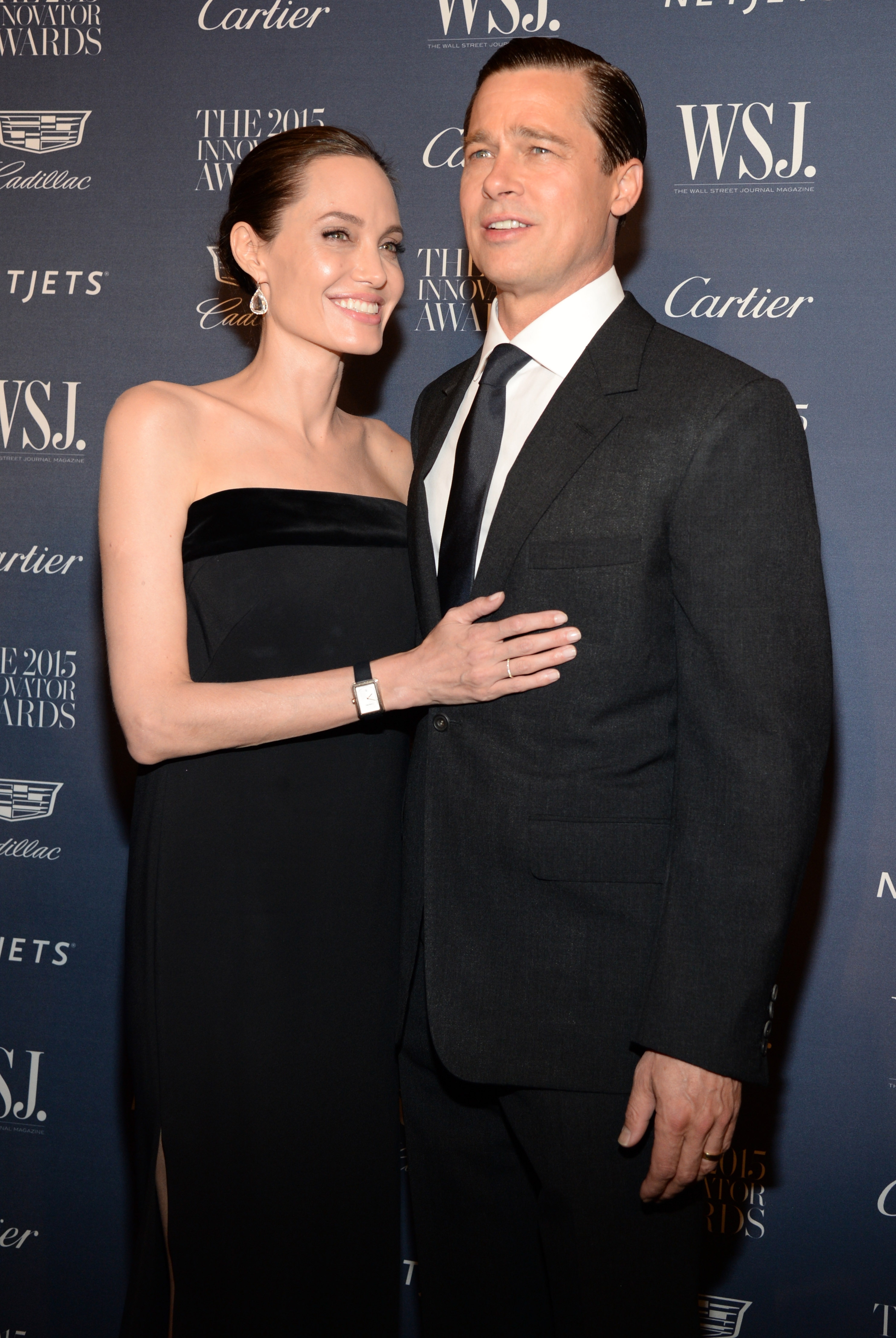 A mates poses connected the reddish carpet astatine an awards event. The pistillate wears an elegant strapless gown, and the antheral is successful a classical acheronian suit and tie