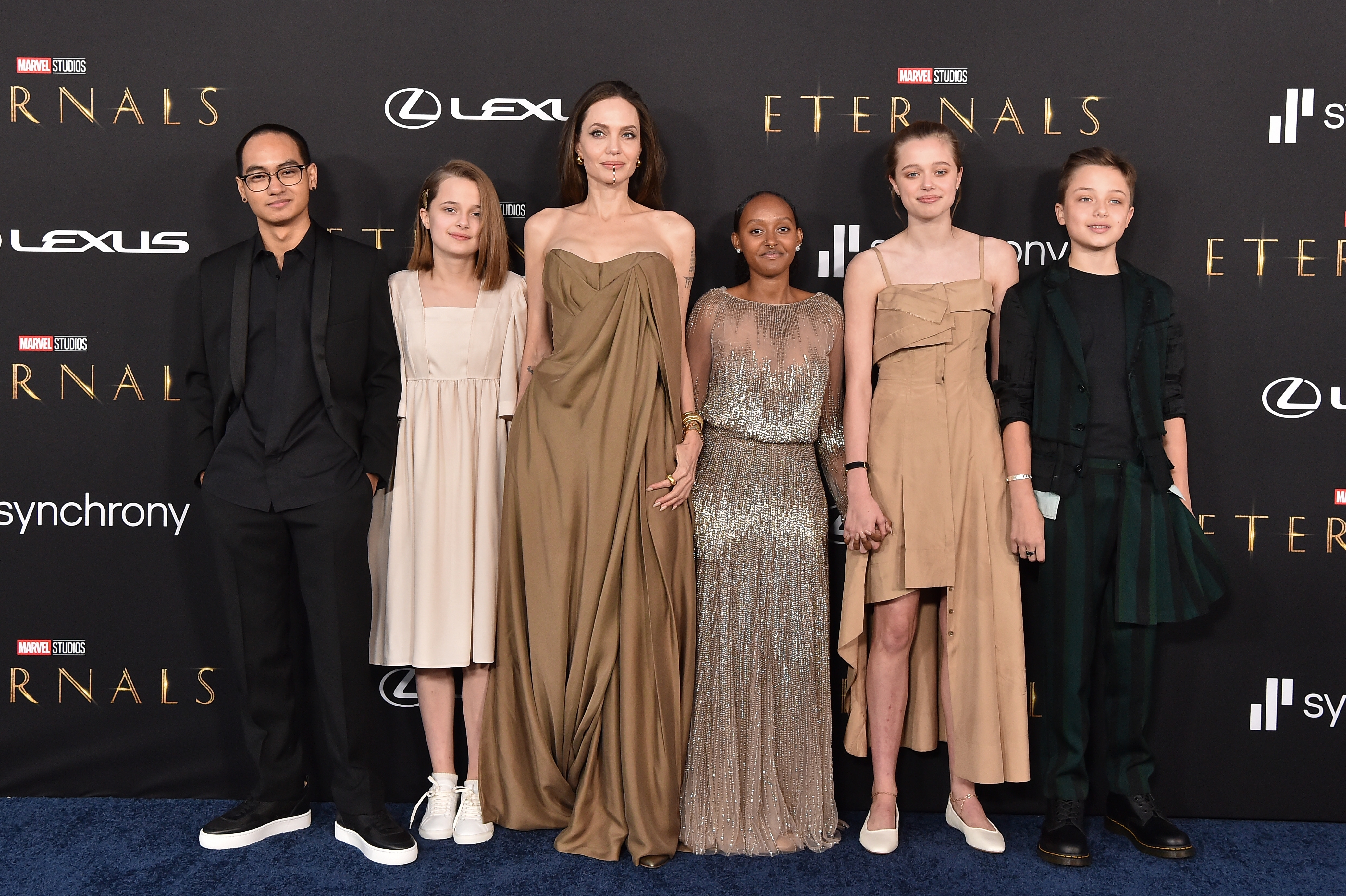 A radical connected a reddish carpet successful elegant attire attending the premiere of "Eternals," posing for photos. The benignant is flowing and fashion-forward